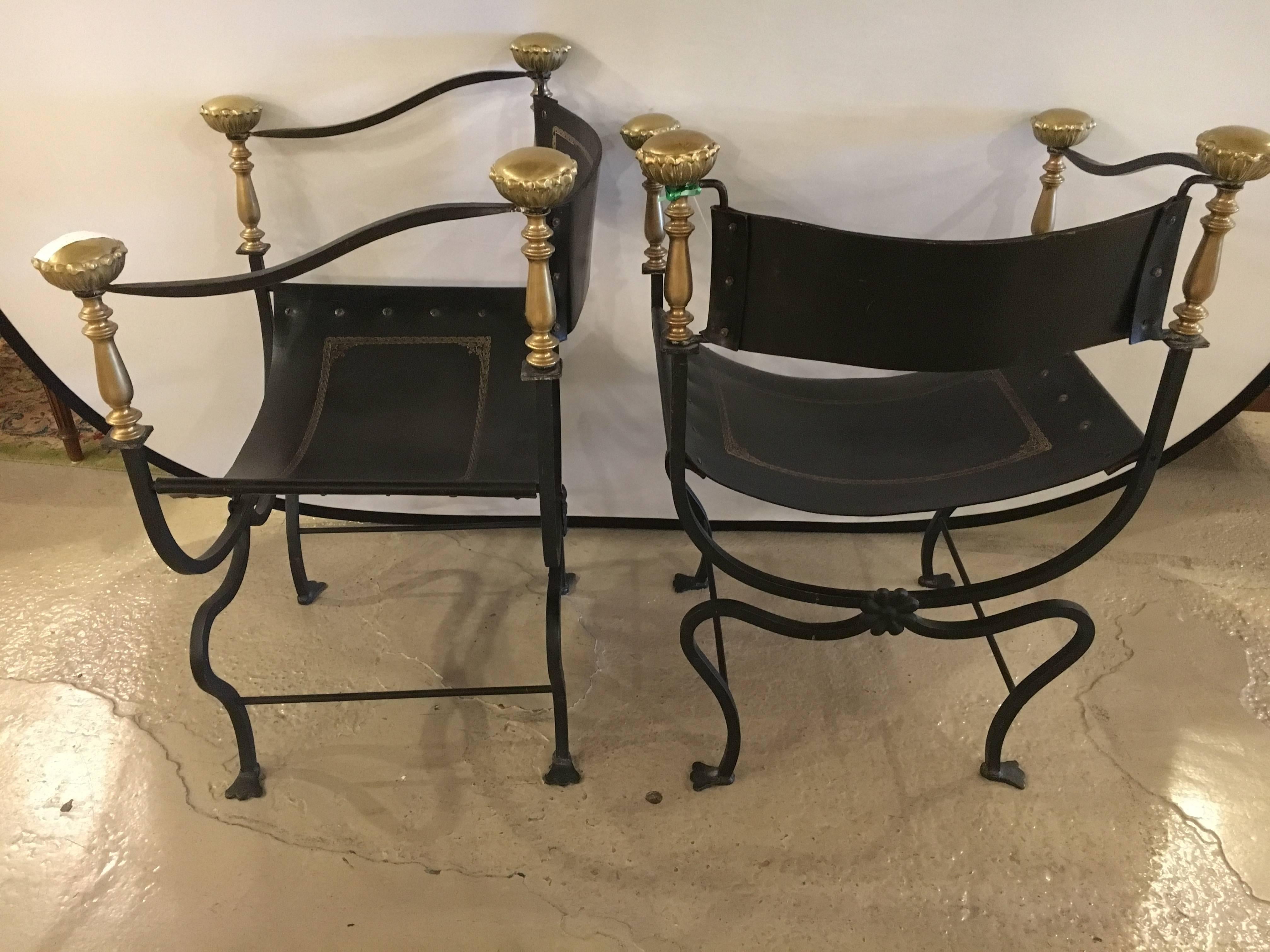 A pair of Jansen Curule Savonarola chairs. Each with a finely tooled leather seat and tooled leather backrest. The wrought Iron base having claw feet and leading to a pair of brass front and back posts. In fine condition.