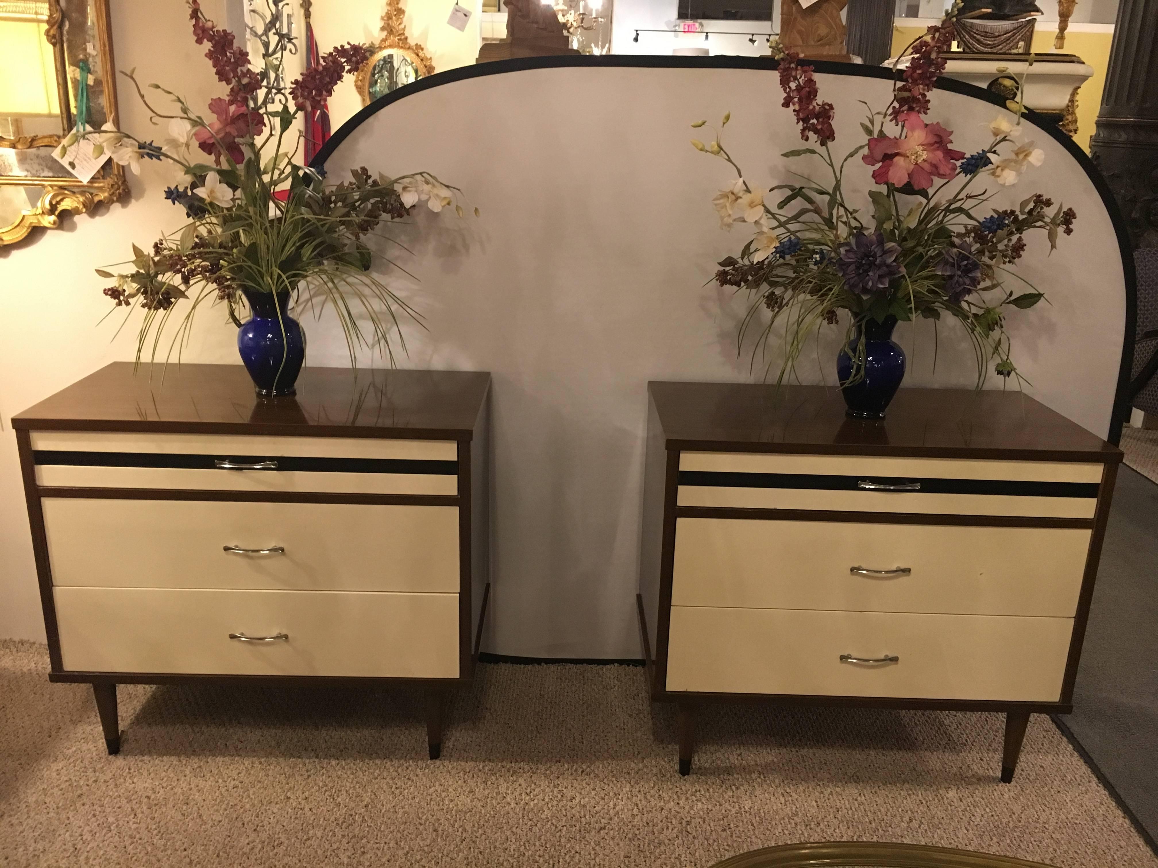 Stylemaker signed pair of Mid-Century Modern bachelor chests or nightstands. Recently polished and waxed. The white and wood fronts sitting on tapering legs. The recently polished piece would make a fine addition to any Mid-Century setting in the