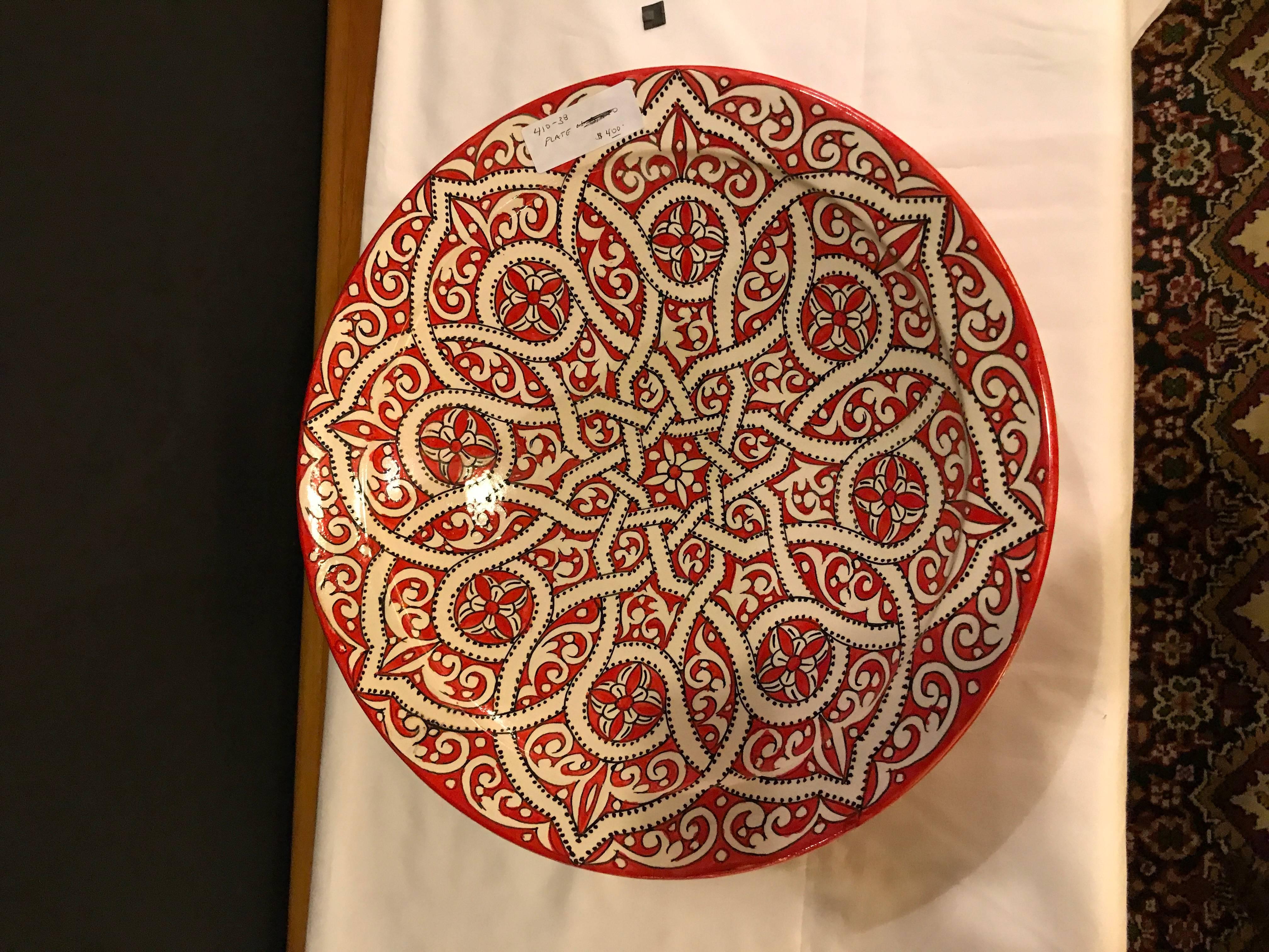 With a beautiful arabesque design hand-painted in cherry red and white, this gorgeous, large-size ceramic dinner plate possesses a truly exotic look. Handcrafted in the bustling workshops of master artisans in the coastal city of Safi, this lovely