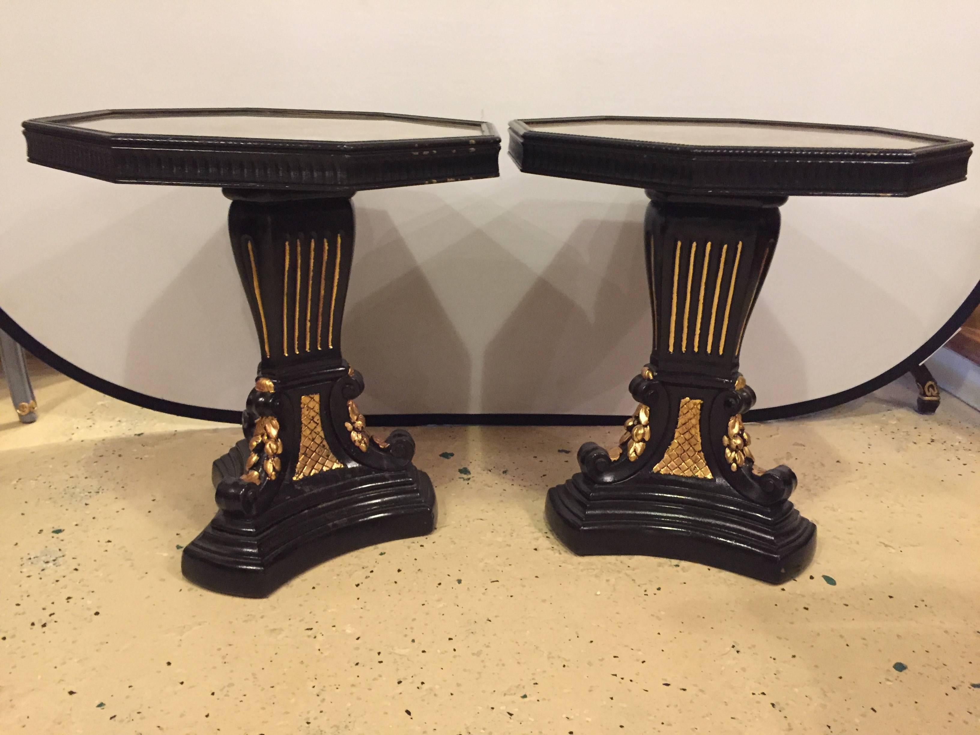 Pair of gilt glass top ebonized and gilt decorated end or side tables. These fine Hollywood Regency side or end tables would surely compliment any area of the home.