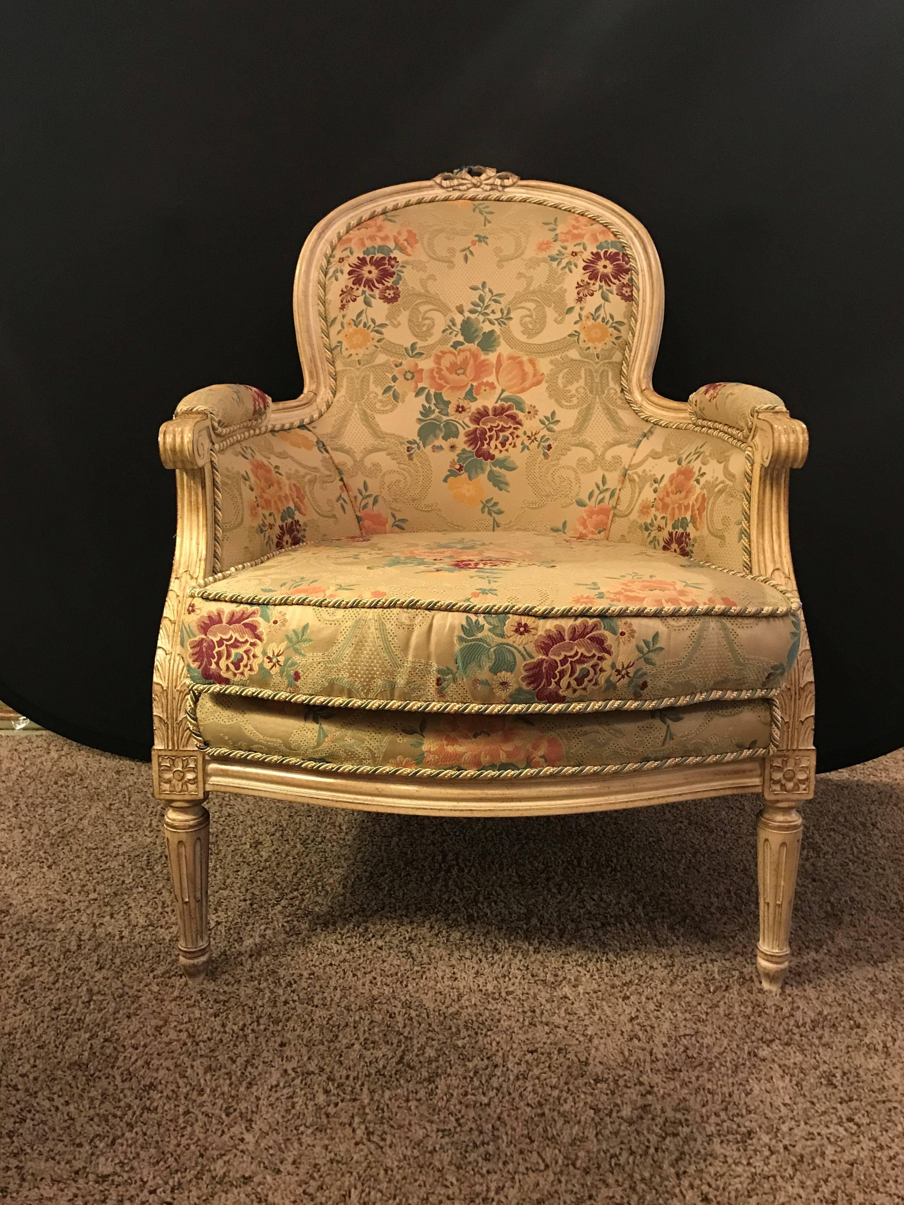 Pair of French Louis XVI style cream painted bergeres with custom floral upholstery. This fine Maison Jansen style pair of armchairs have a wonderful fabric of tweed with floral design. The finely carved and distressed frames in the Louis XVI style