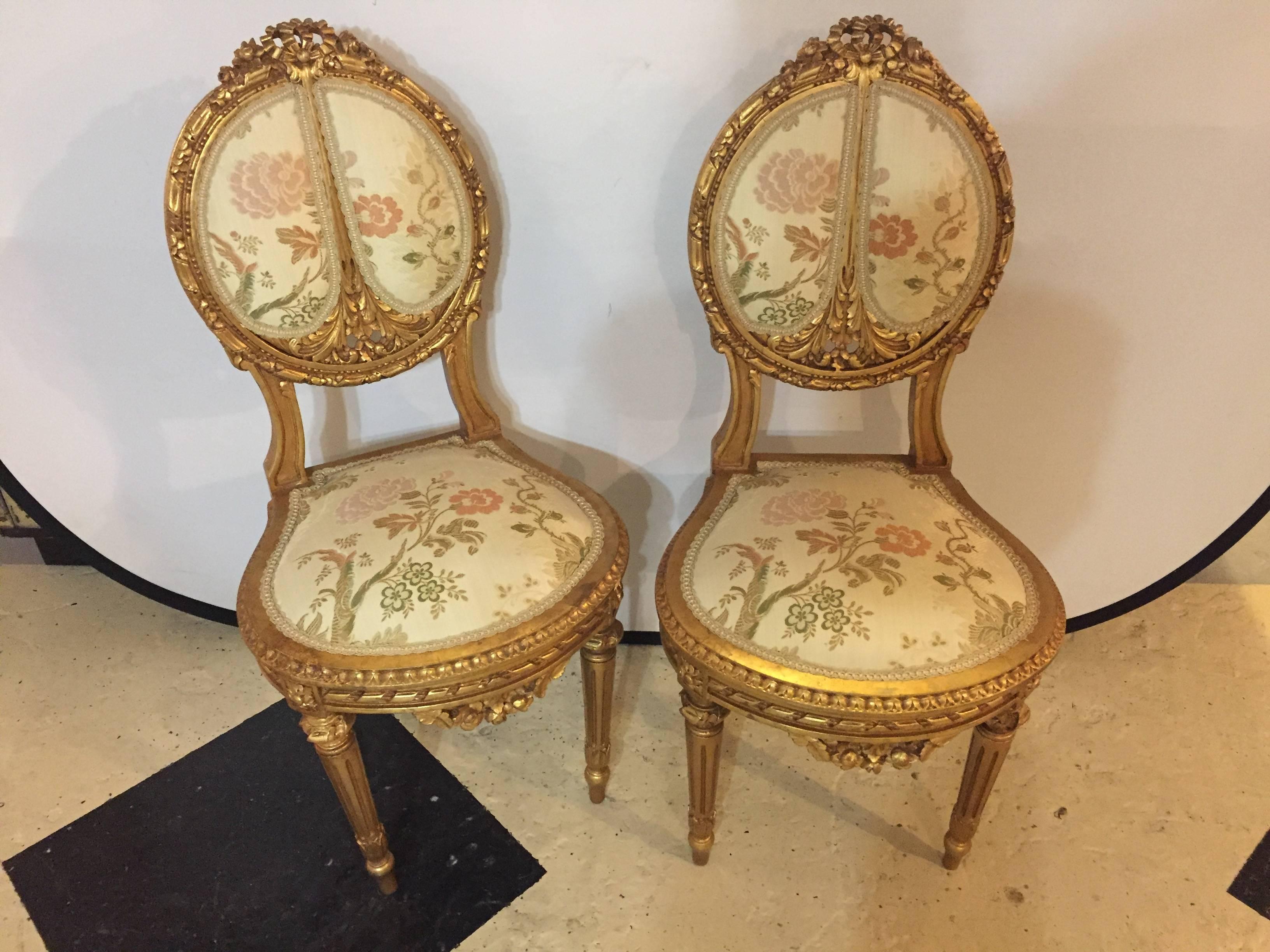 Set of four Louis XVI side chairs each in a fine gilt gold wood finish with carved frames. Having carved roses throughout and tapering legs. Part of a salon set that includes a sofa and pair of bergere chairs, sold separately. This finely carved set