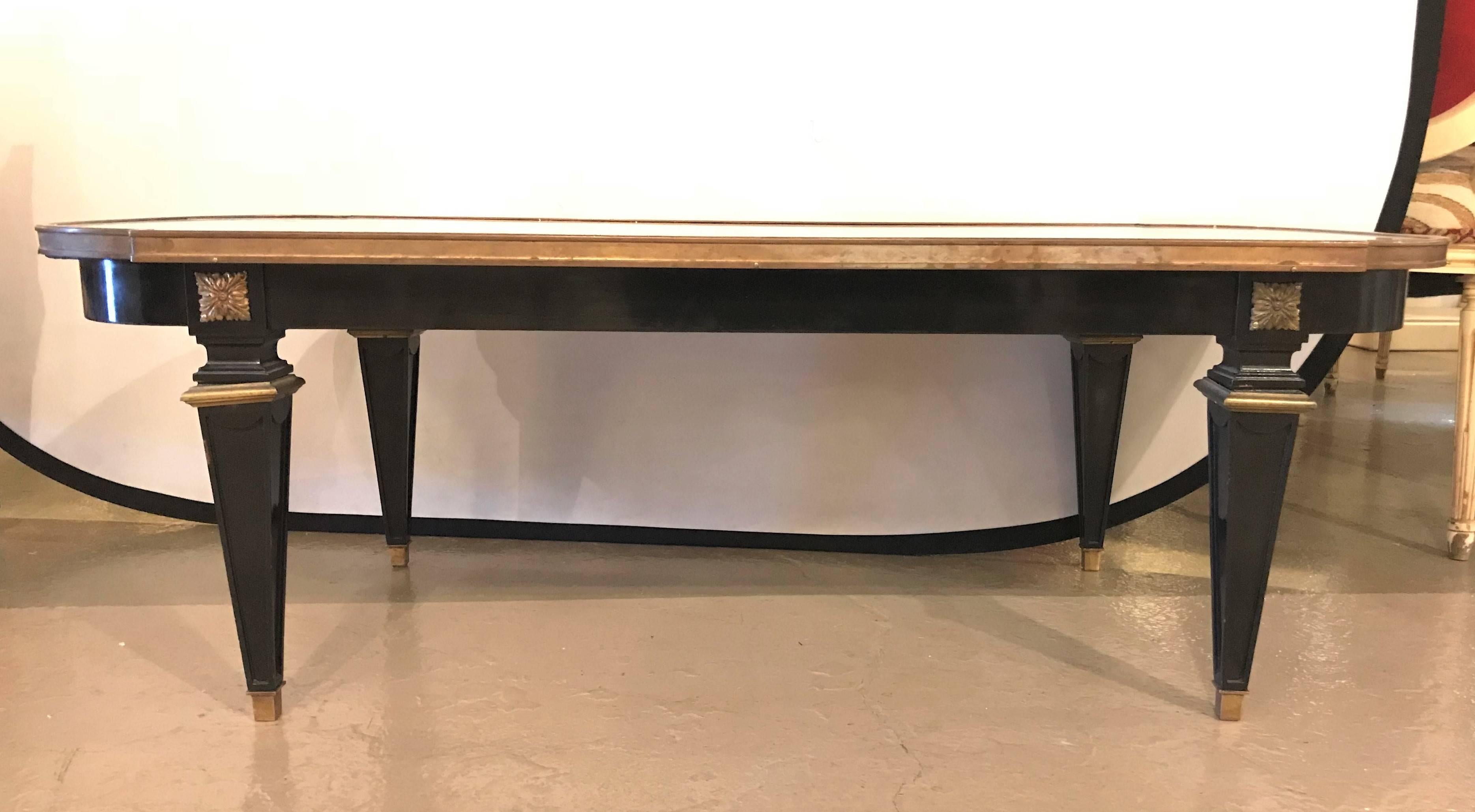 Ebonized marble-top coffee table stamped Jansen in the Louis XVI fashion with bronze mounts. This recently ebonized coffee table base supports a white marble top with gray veins that sits in a bronze frame. This finely constructed coffee table