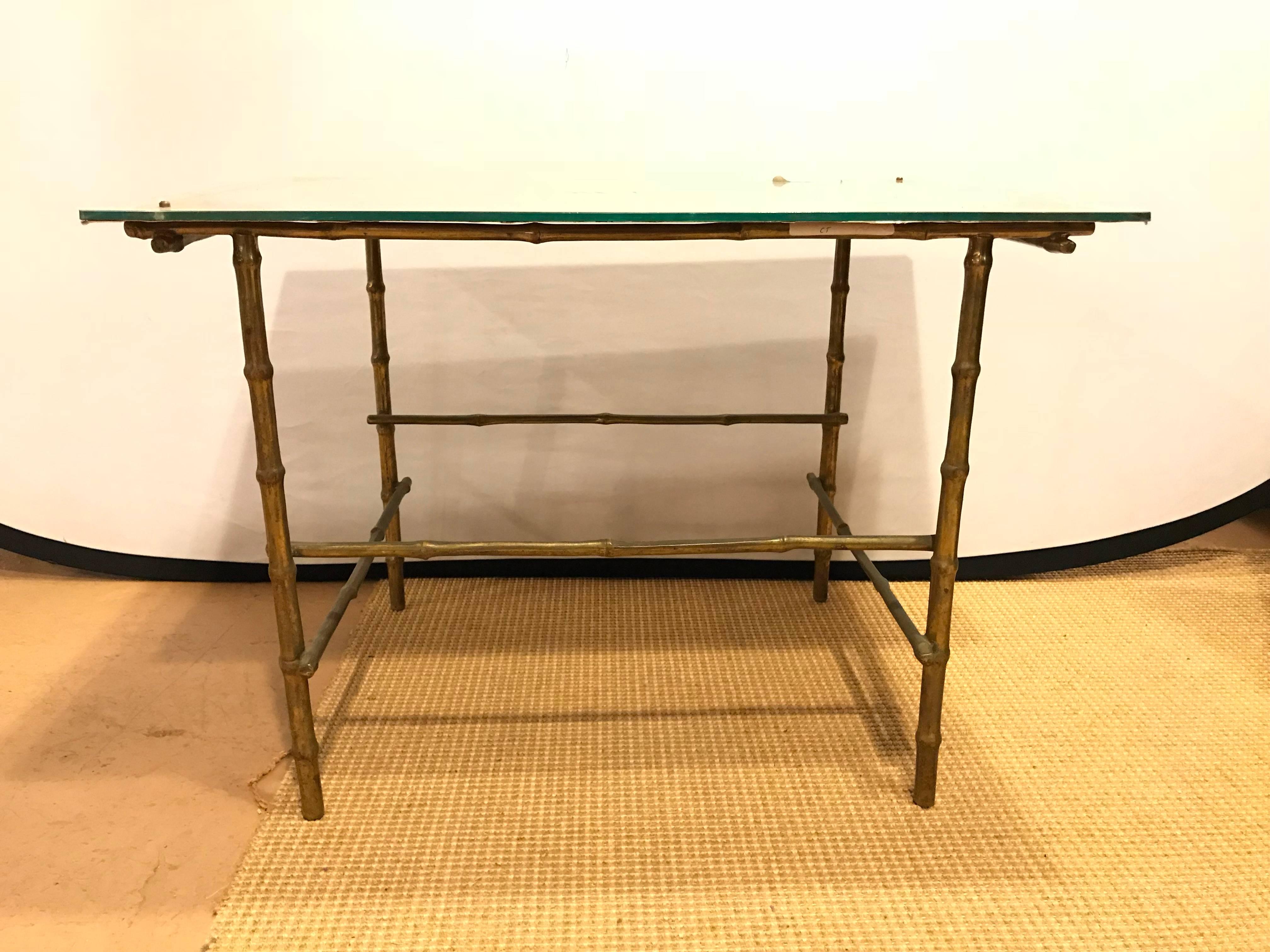 Bronze based églomisé top coffee table. The bottom bronze or gilt base bamboo form table having a line undercarriage supporting a square églomisé silver gilt tabletop with a geometric gold gilt design.