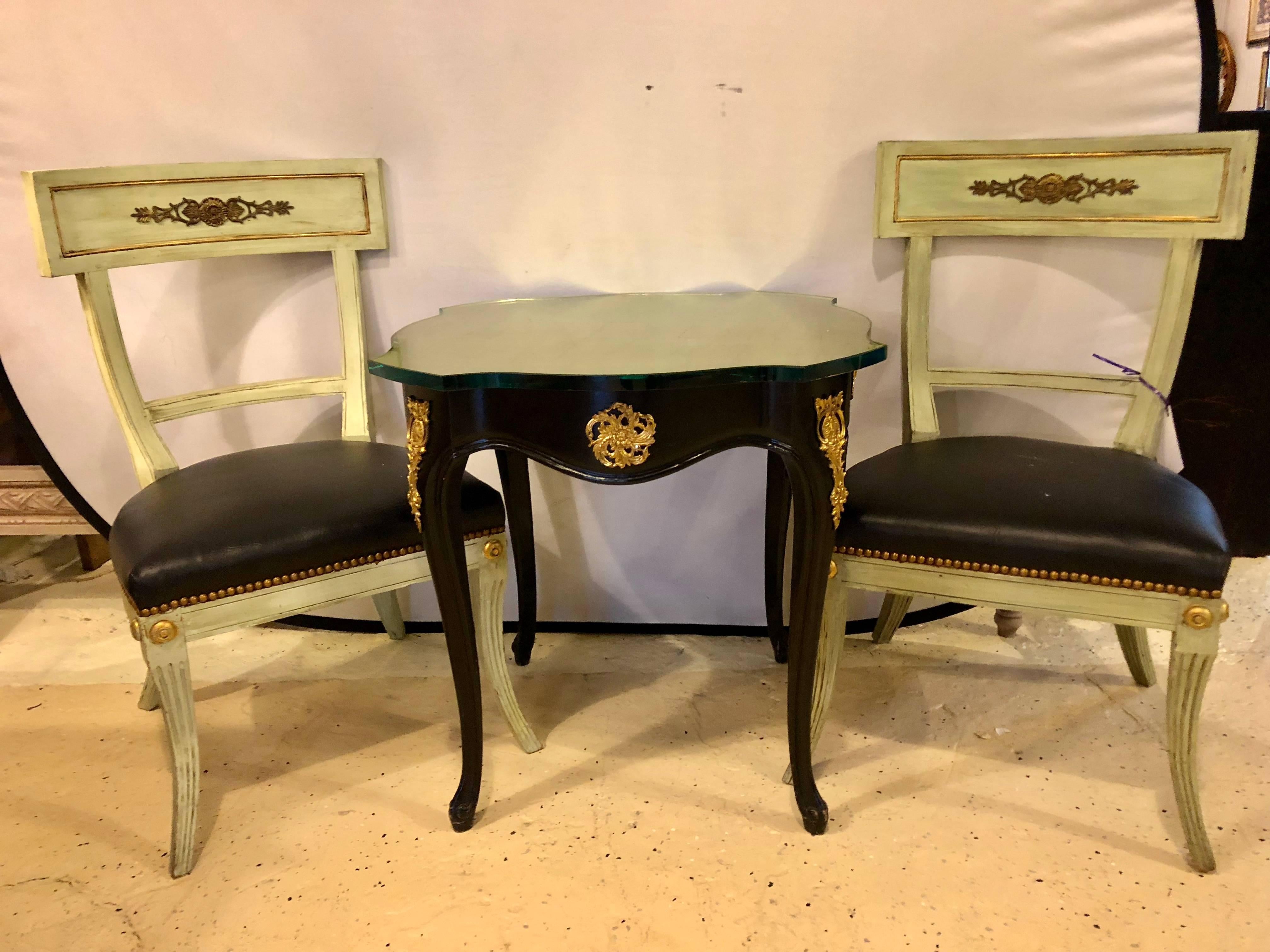 A Louis XV Maison Jansen style side table or pedestal with gilt glass top. This finely bronze-mounted table base is fashioned in the Hollywood Regency style with a fine gilt glass tabletop on an ebonized base.