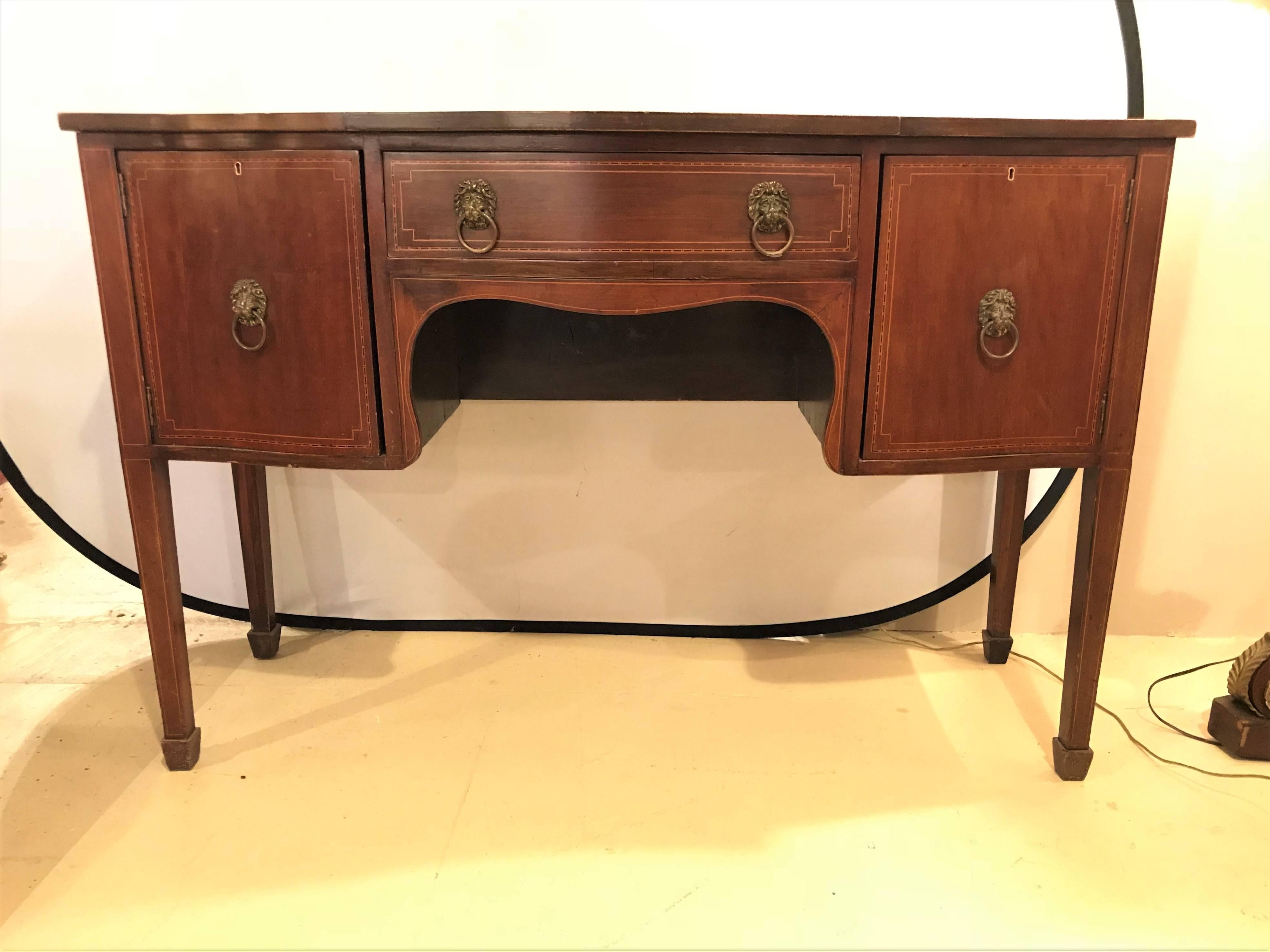 A 19th century Georgian style sideboard or server with inlays. This sideboard or server has a centre drawer flanked by two doors, one having a fitted drawer inside, all having lion head brass pulls. Fine line inlaid decorated. Recently hand rubbed