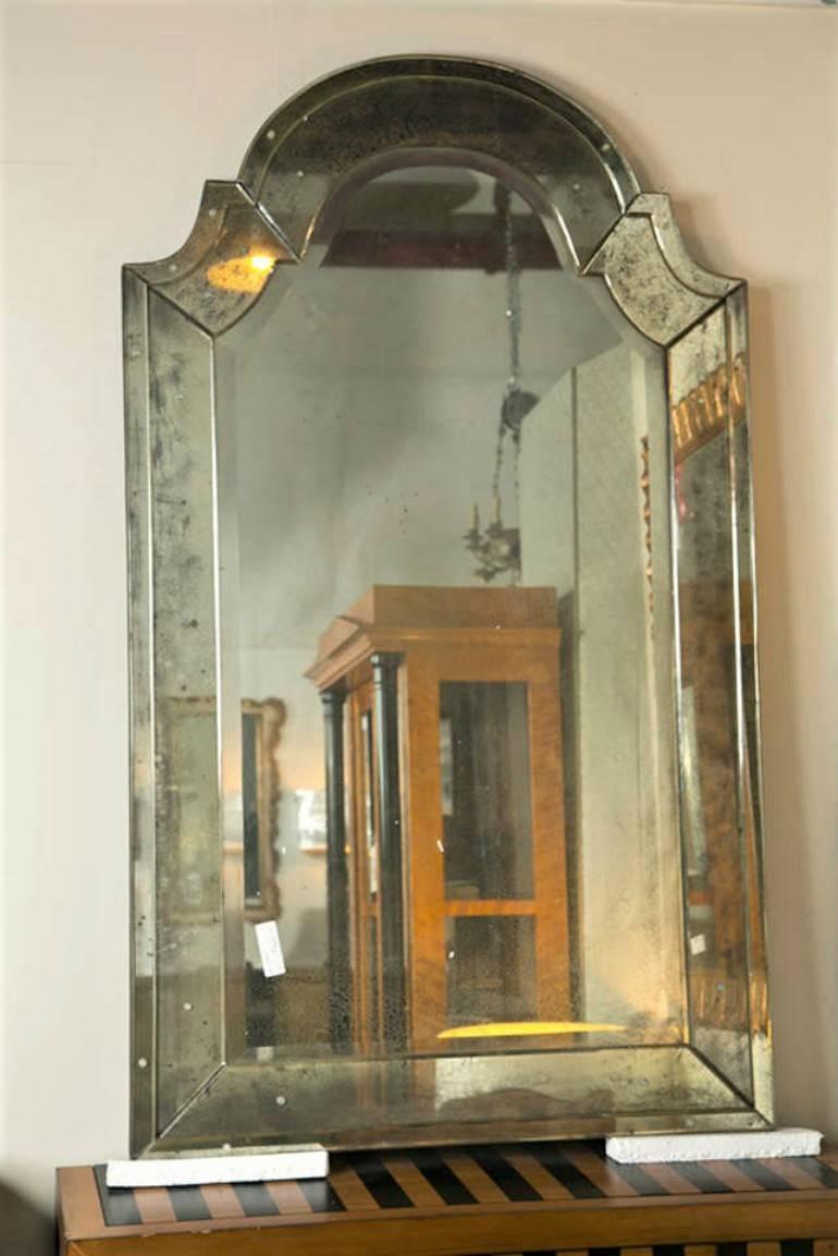 Pair of attractive Classic Venetian style mirrors. Each having domed tops flanked by a set of C-shaped inverted ends leading to a distressed bevelled glass-panel border. The central mirror slightly less distressed than the framing. Some in clean