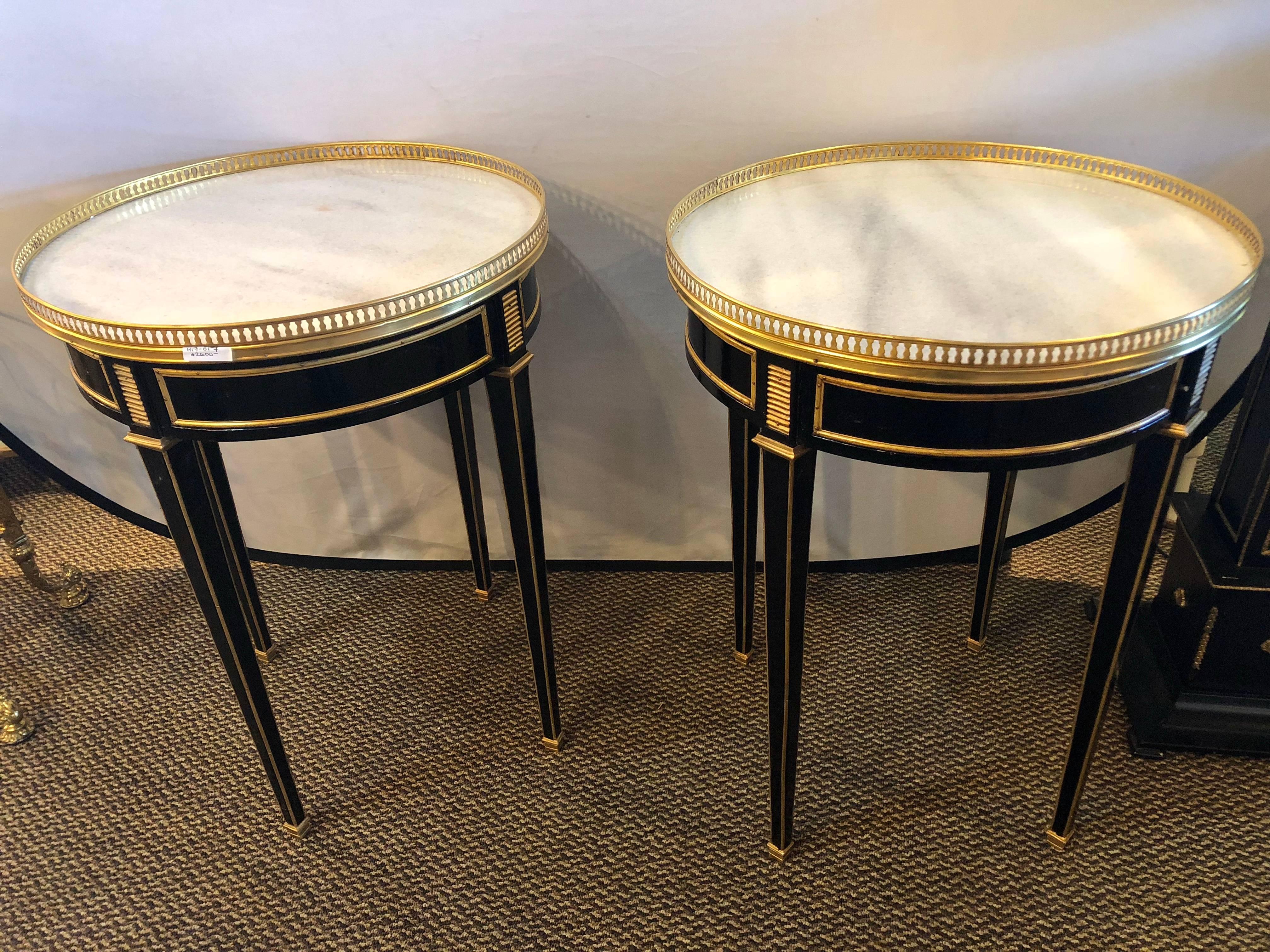 This is a fine pair of Louis XVI style ebony pierced bronze galleried Bouillotte or end tables in the manner of Maison Jansen depict the Hollywood Regency era at its height. On bronze sabots the ebony tapering legs have this very rare and fine