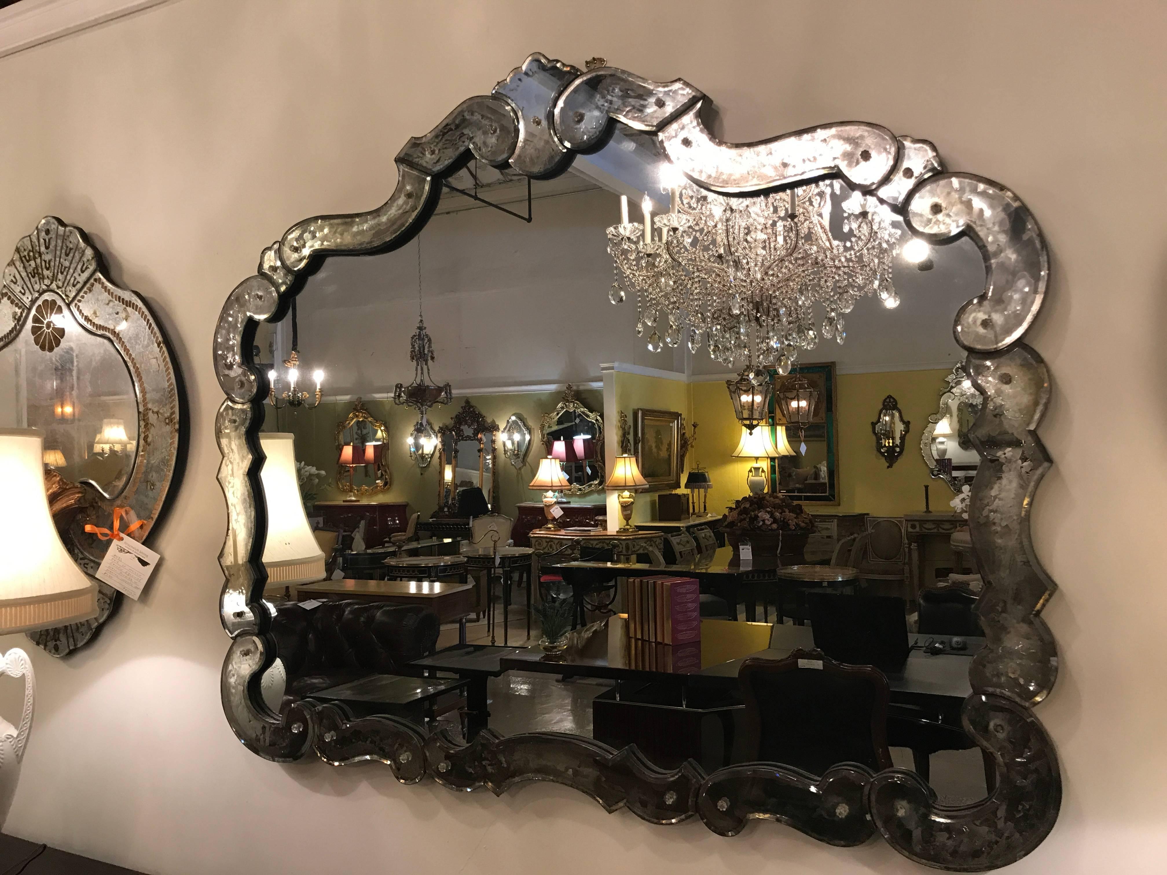 A fine Venetian style circa 1930s vanity or over the mantel mirror. This mirror in very fine condition lends old world Hollywood Regency style to any room in the home or office. The distressed bevelled frame of multiple parts flanks the central