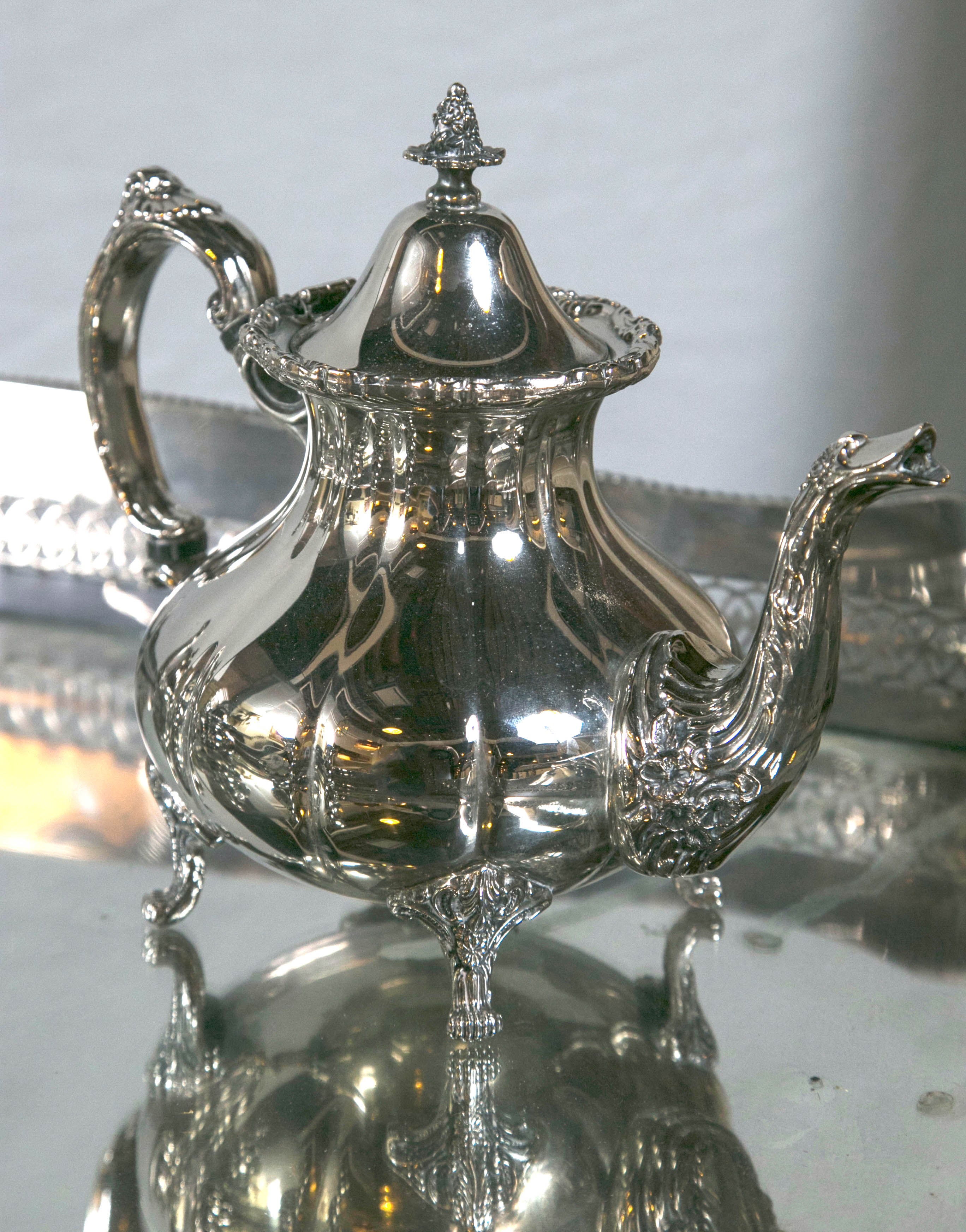 Hollywood Regency silver plated four tea service. A wonderful addition accent piece to any room setting. Tray and table not included. The largest piece measures 11 x 10 x 6.