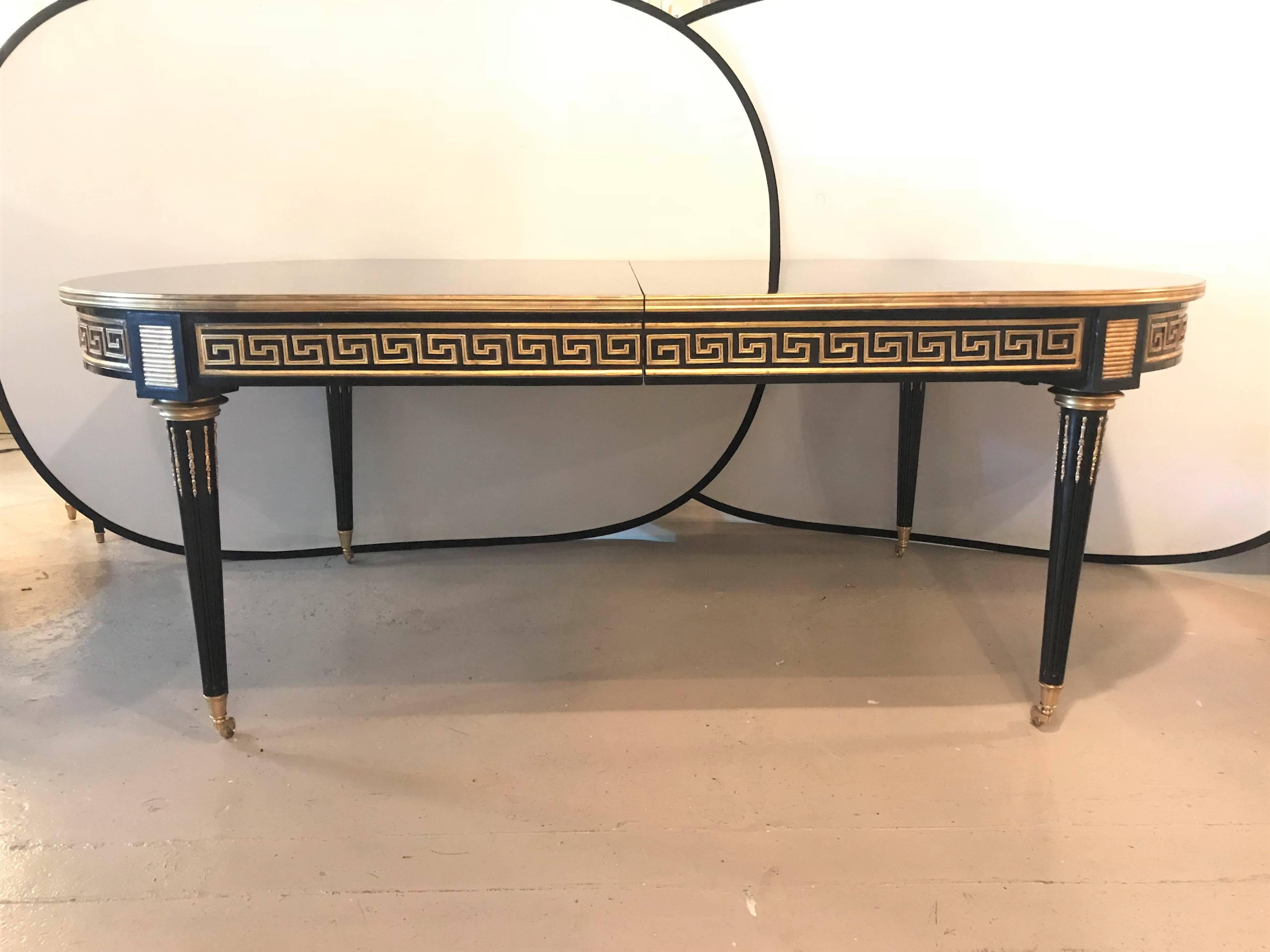 Hollywood Regency at its finest in this one of a kind Maison Jansen inspired 12 foot bronze-mounted Greek key design dining room table each of the three bronze-mounted leaves measure 19.5 inches. This table at almost four feet wide and 84 inches