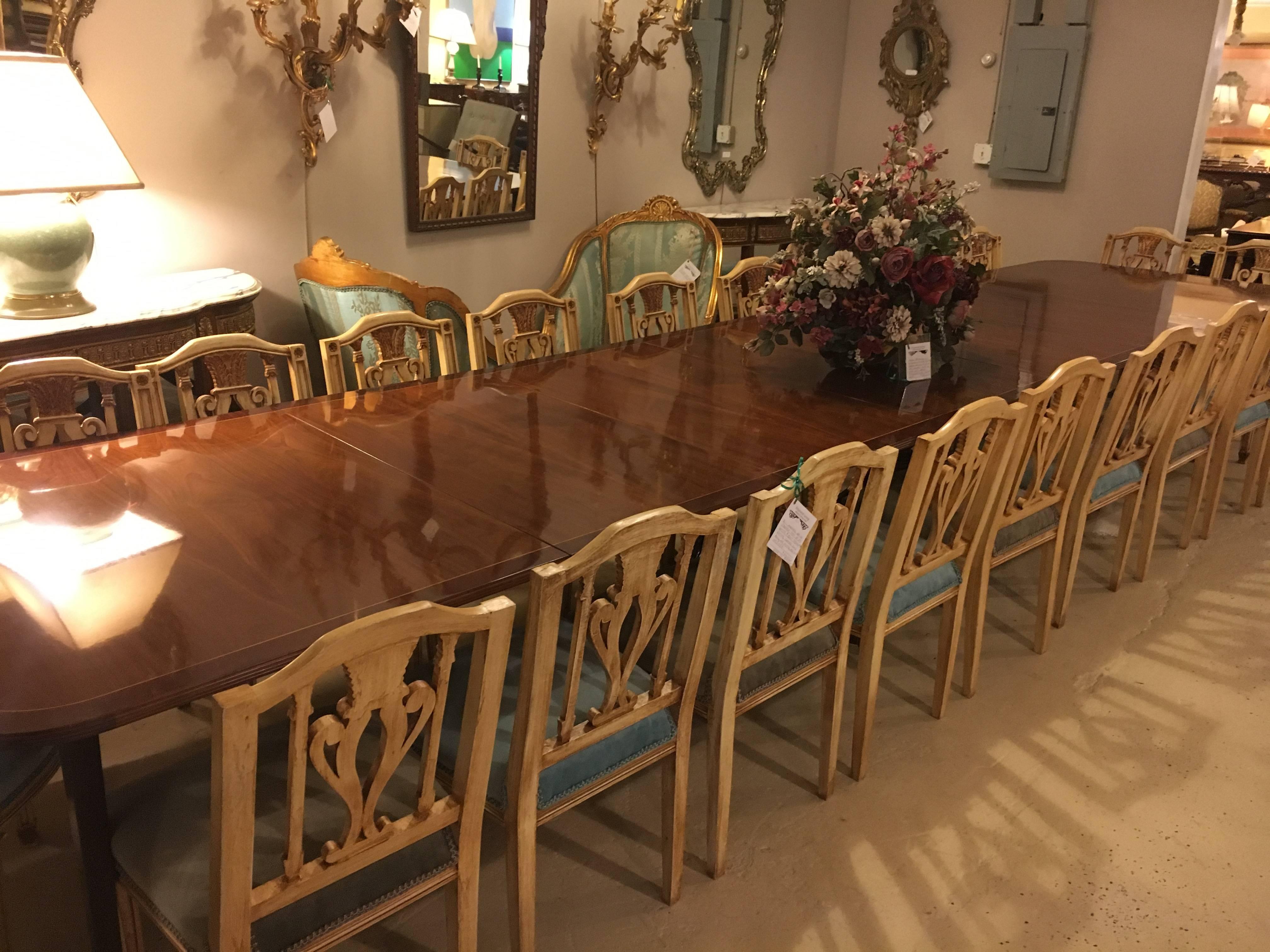 Finest monumental English Georgian style dining table sits a whooping 16+ feet and is in spectacular condition.  This one of a kind double pedestal dining table is custom crafted from fine mahogany with a wonderful rosewood banding on the outer