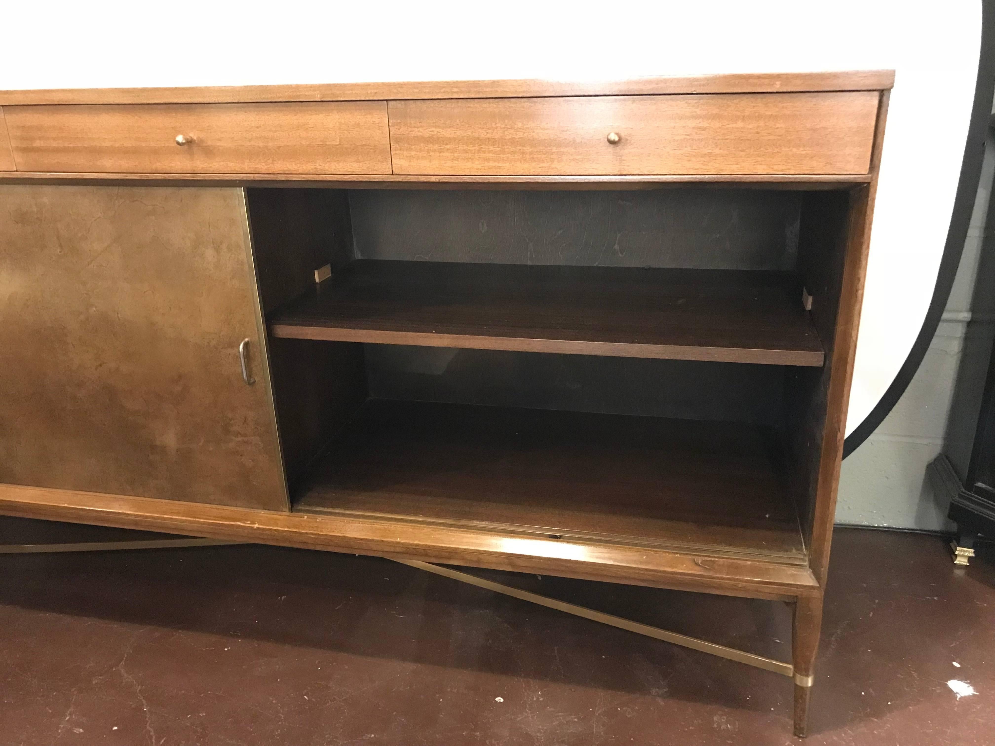 Paul McCobb for Calvin Group credenza. Handsome credenza by Paul McCobb for the Calvin Group. Leather doors and polished brass supports. Exceptional condition. Original tags inside drawers.
