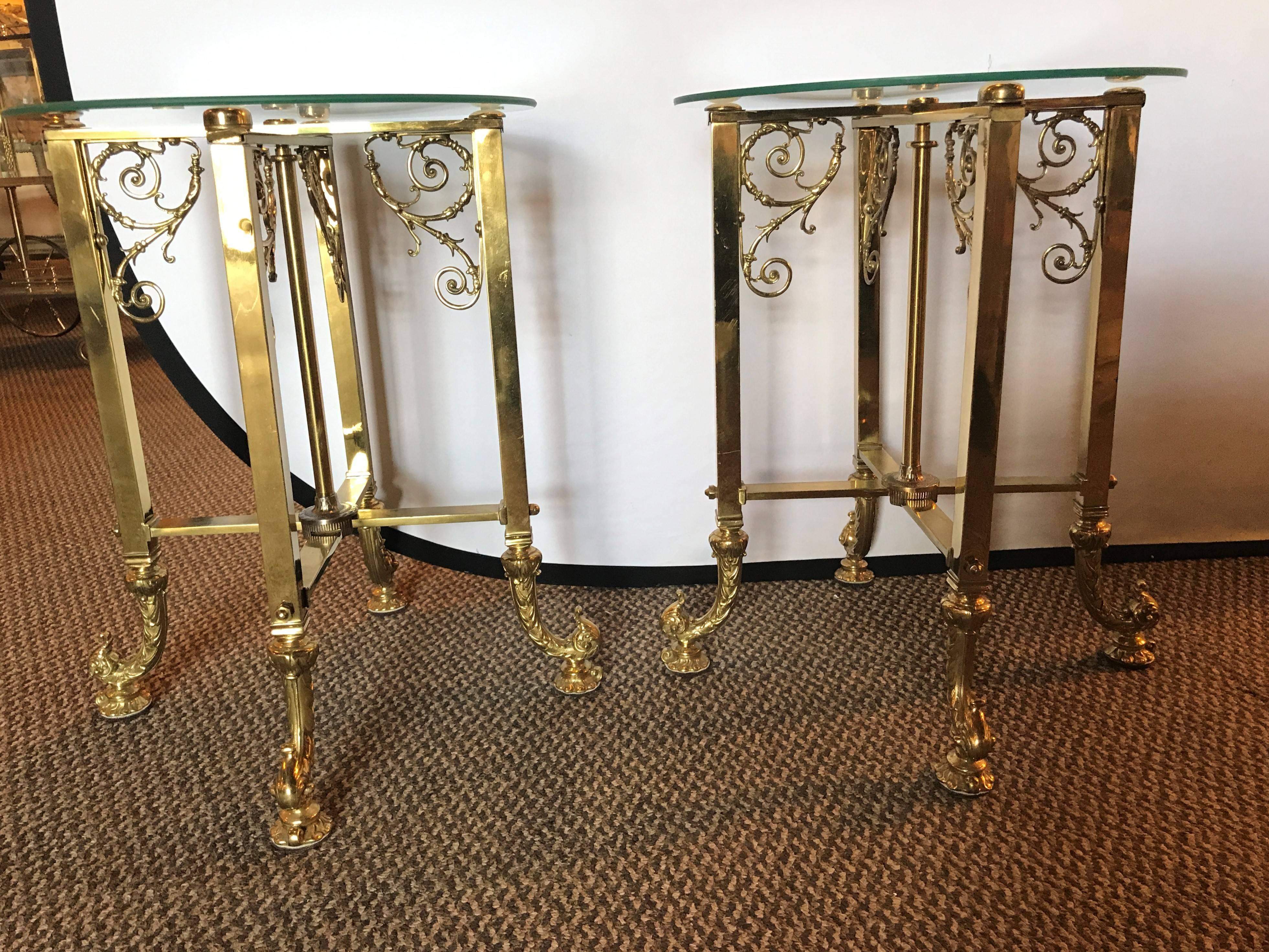 A pair of fine bronze based end tables with glass tops. Hollywood Regency pair of bronze end tables with scroll and vine design each having a circular glass top. Both tables have a locking mechanistic which pulls up and down from the center bar.
