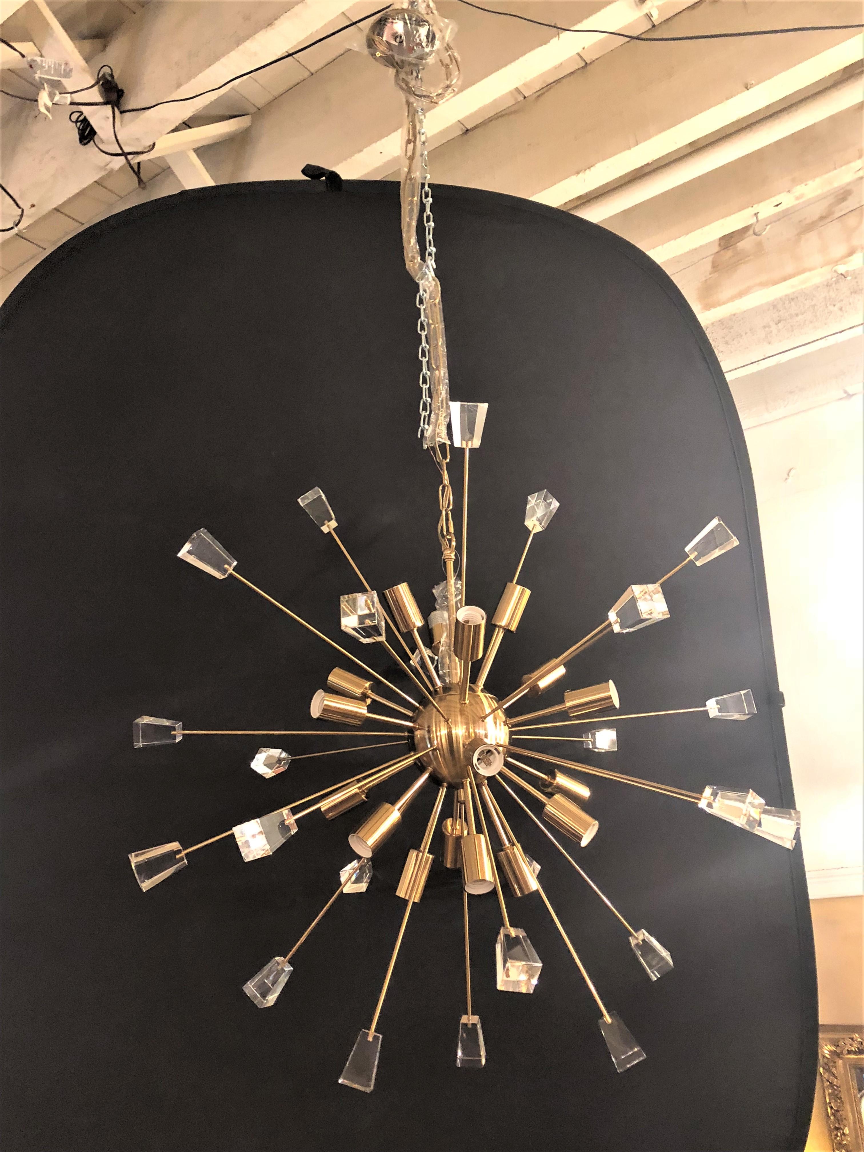 A pair of brass eighteen-light Sputnik chandeliers in the Mid-Century Modern style. This pair come with a matching canopy and a chain that is approximately 54 inches long. Having a brass sphere in the center emanating many brass arrow like rods many