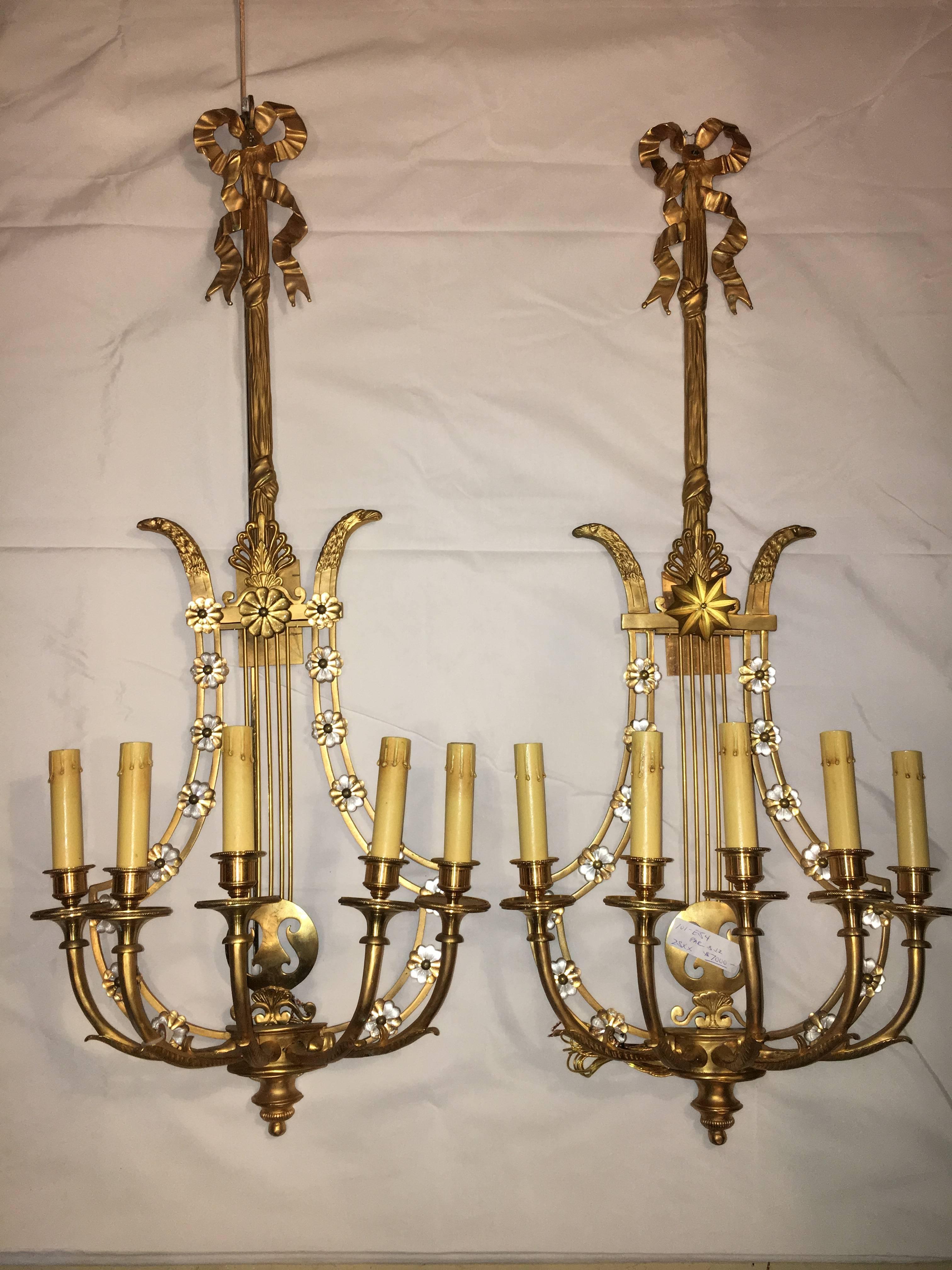 Groupe de six appliques murales de style Louis XVI à dos de harpe en bronze. Cette belle paire, qui rappelle l'époque Hollywood Regency, est en bronze massif. Chacune d'entre elles présente un motif de dos de harpe avec des rosettes en cristal. La