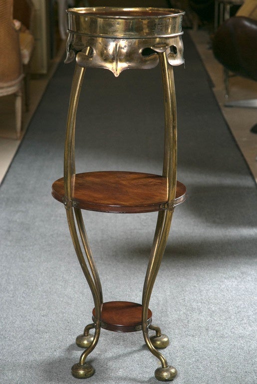 Pair of Art Deco brass rosewood pedestal stands. Great looking pair of Art Deco pedestal stands. The brass circular feet leading to brass side supports. The central rosewood shelves stand 16.5