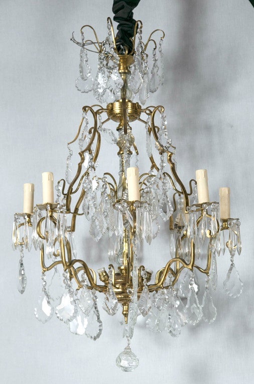 A finely cast pair of eight-arm bronze and crystal chandeliers. Exquisitely set and displayed. Layers of glorious divisions of crystals surround the crystal column form center with fine support of bronze. Recently rewired.