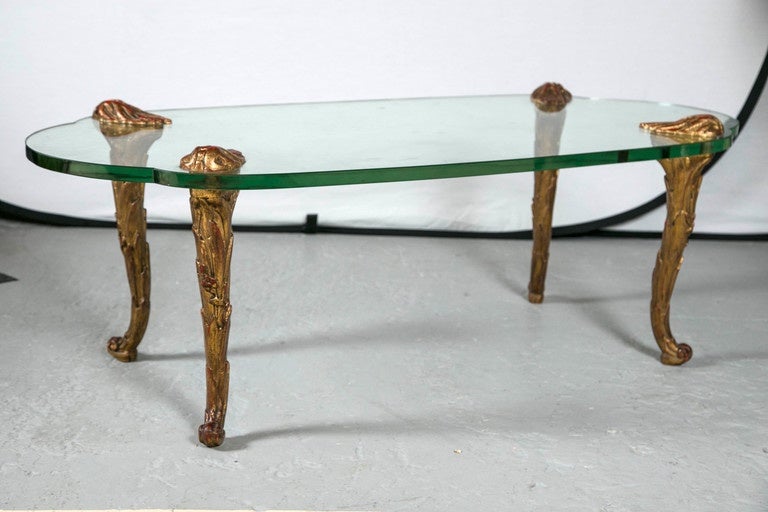 Fine gilt metal coffee table in the Bagues or Jansen style. The carved curved feet supporting a oval glass top.