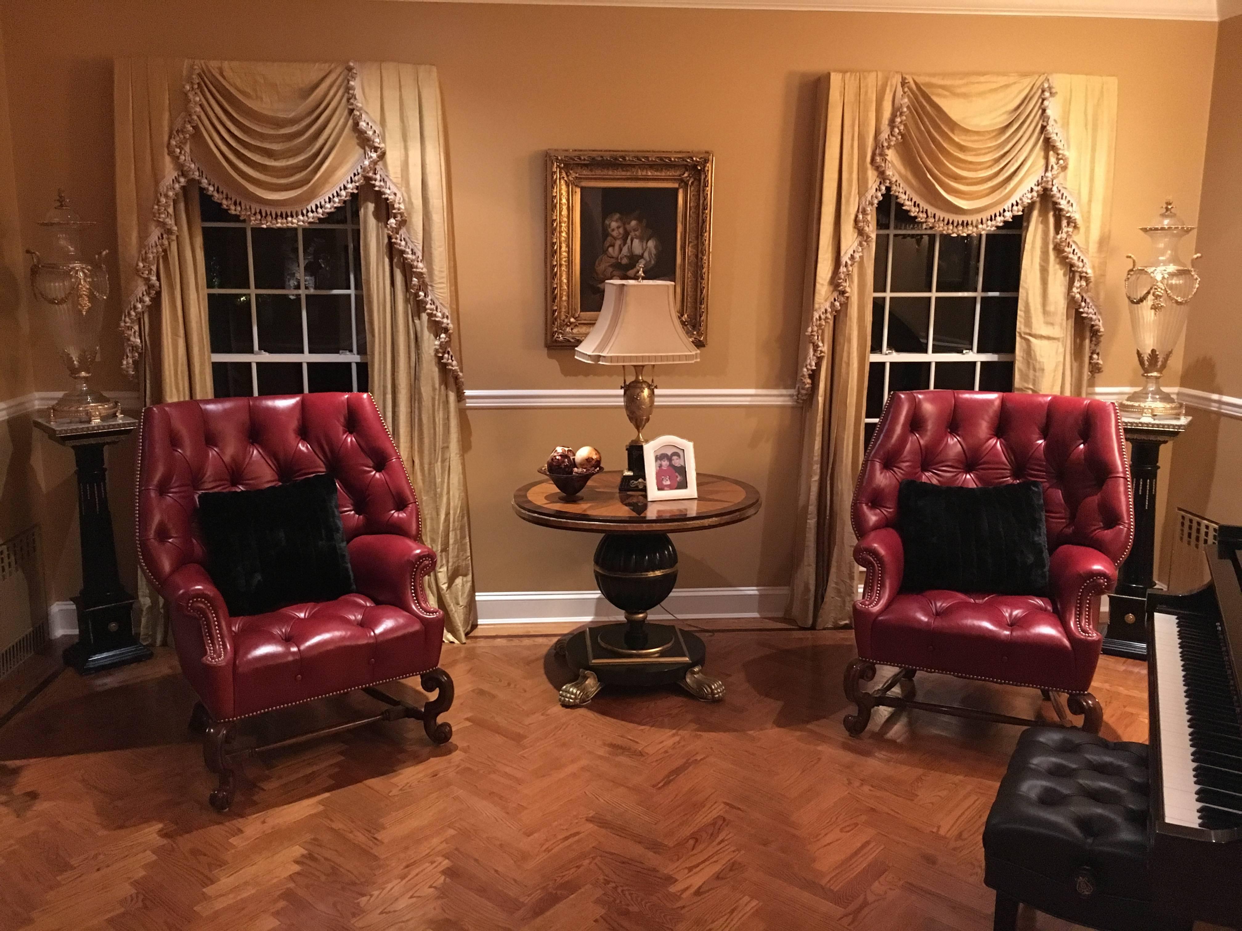Pair of oversized tufted leather wingback chairs. Simply the finest custom quality leather bow back chairs sitting on walnut solid carved frames with barley twisted undercarriages. The wide back and seats having enormous comfort and room. Fully