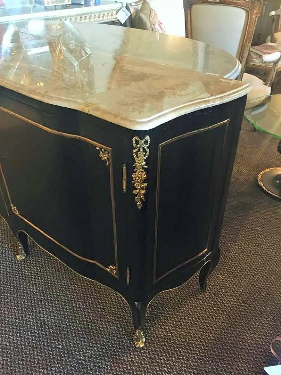 Pair of marble-top or commodes with bronze mounts. Fine pair of French bombe style commodes in the Maison Jansen fashion. Each having two doors leading to oak secondary shelving compartments. Finely bronze mounted and ebonized with a nice French