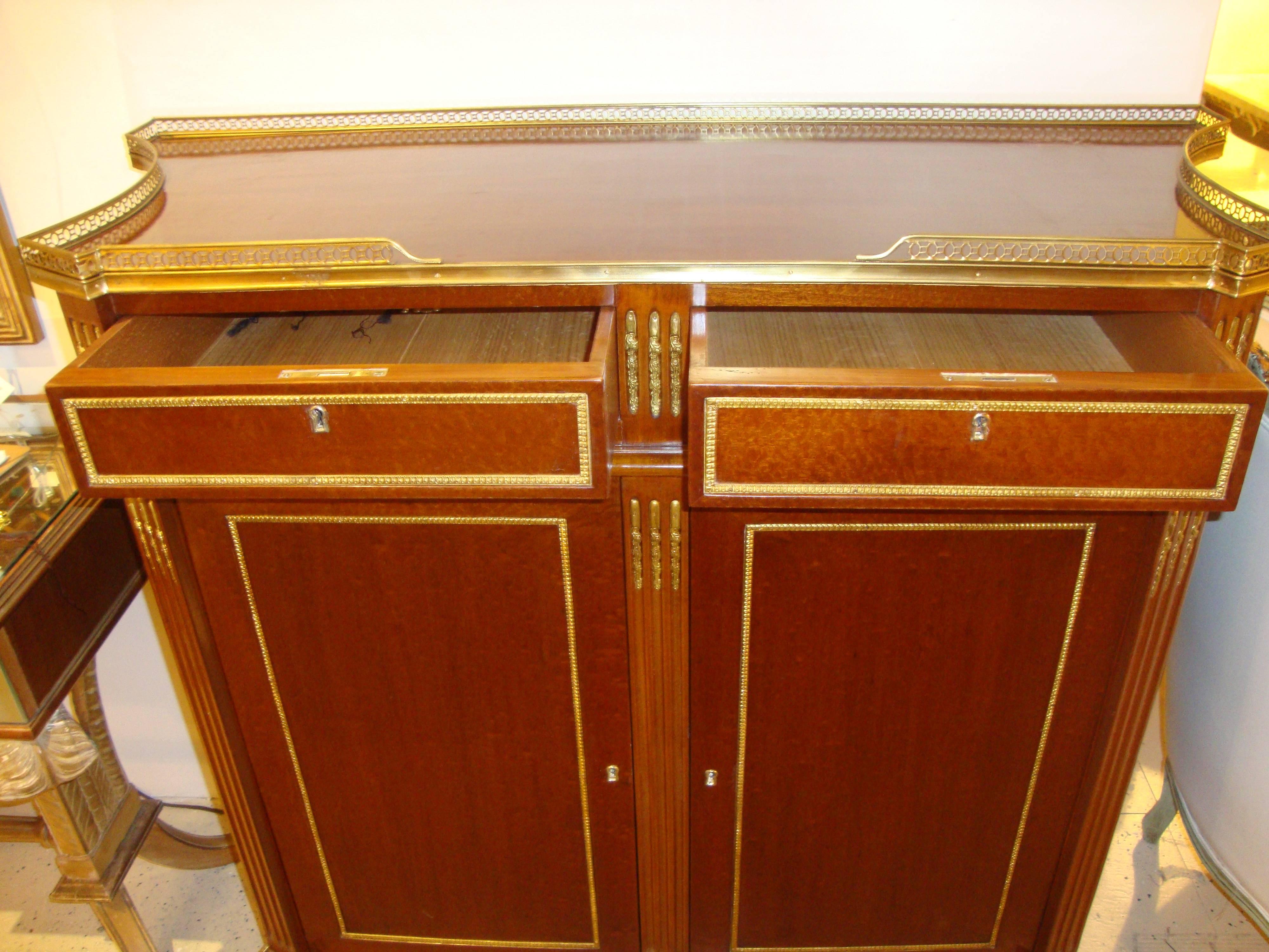 Pair of Russian neoclassical inspired double door cabinets. Each having a wonderfully polished burl mahogany finish with heavy bronze mounts reminiscent of the Russian Neoclassical Era. The bronze pierced gallery sitting atop two drawers over two