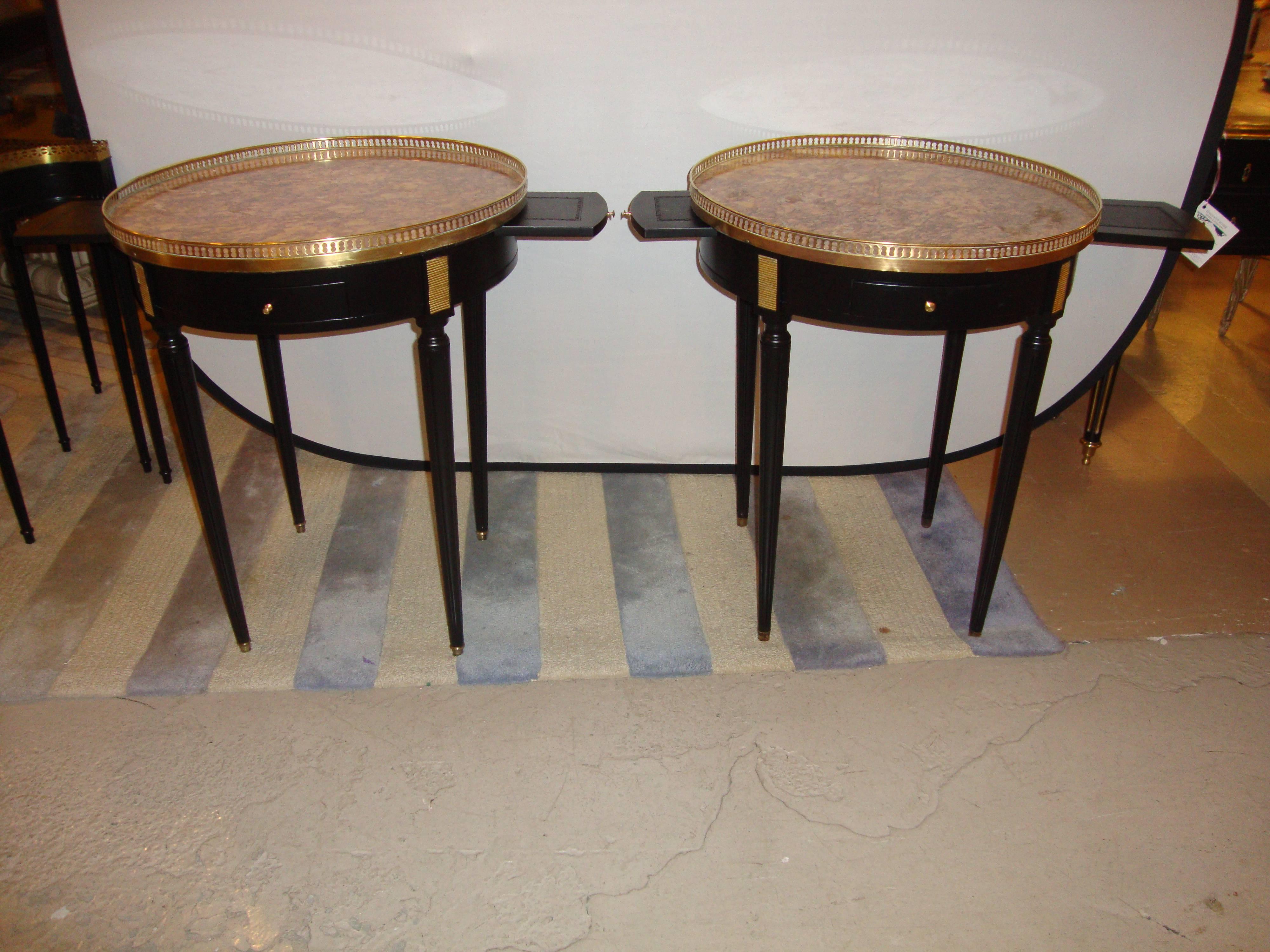Pair of Maison Jansen Bouillotte or end tables. These finely constructed Bouillotte or end tables each have a pierced bronze gallery framing the rose colored marble top. The top supported by a recently refinished ebony base having drawer and