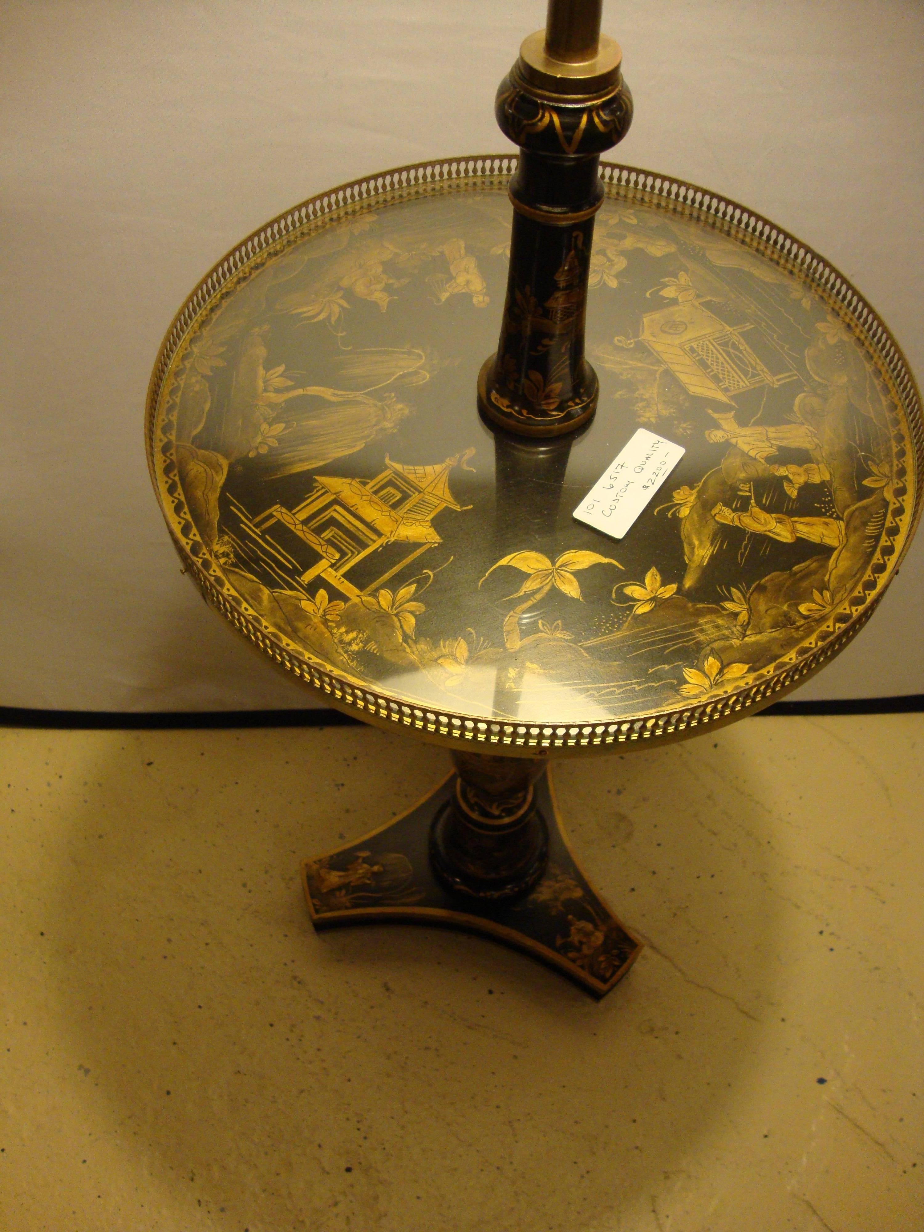 A decorative chinoiserie tray table / stick lamp. The finely decorated tripod base supporting a chinoiserie decorated column leading to a glass covered chinoiserie tabletop terminating into a matching column leading to a double socket lamp with