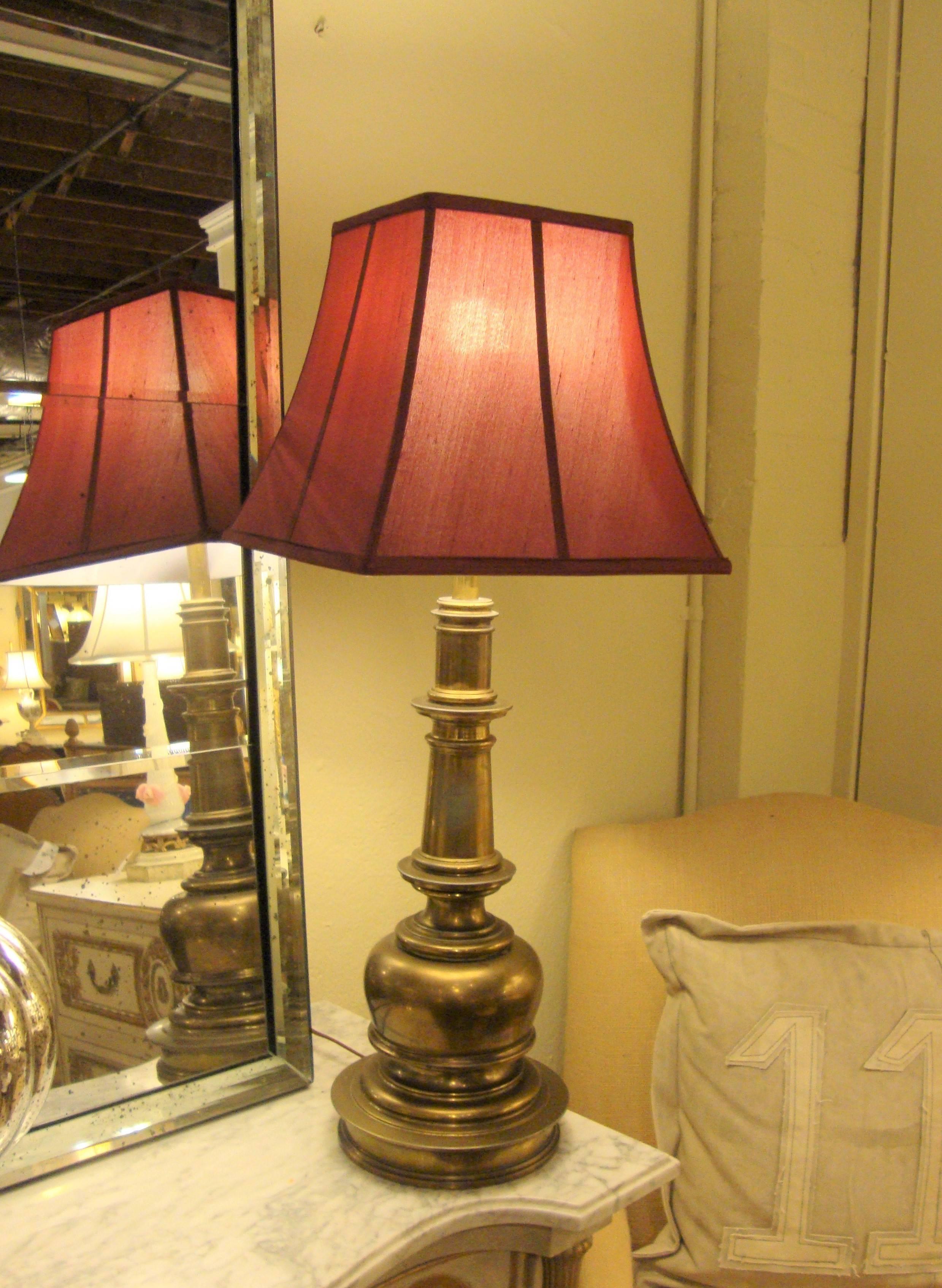 A fine bronze pair of table lamps in the neoclassical fashion. These lamps having a bulbous column center supporting a custom quality pair of lamp shades. The pair are certain to light up any room in the home of office. From a Massapequa home of a