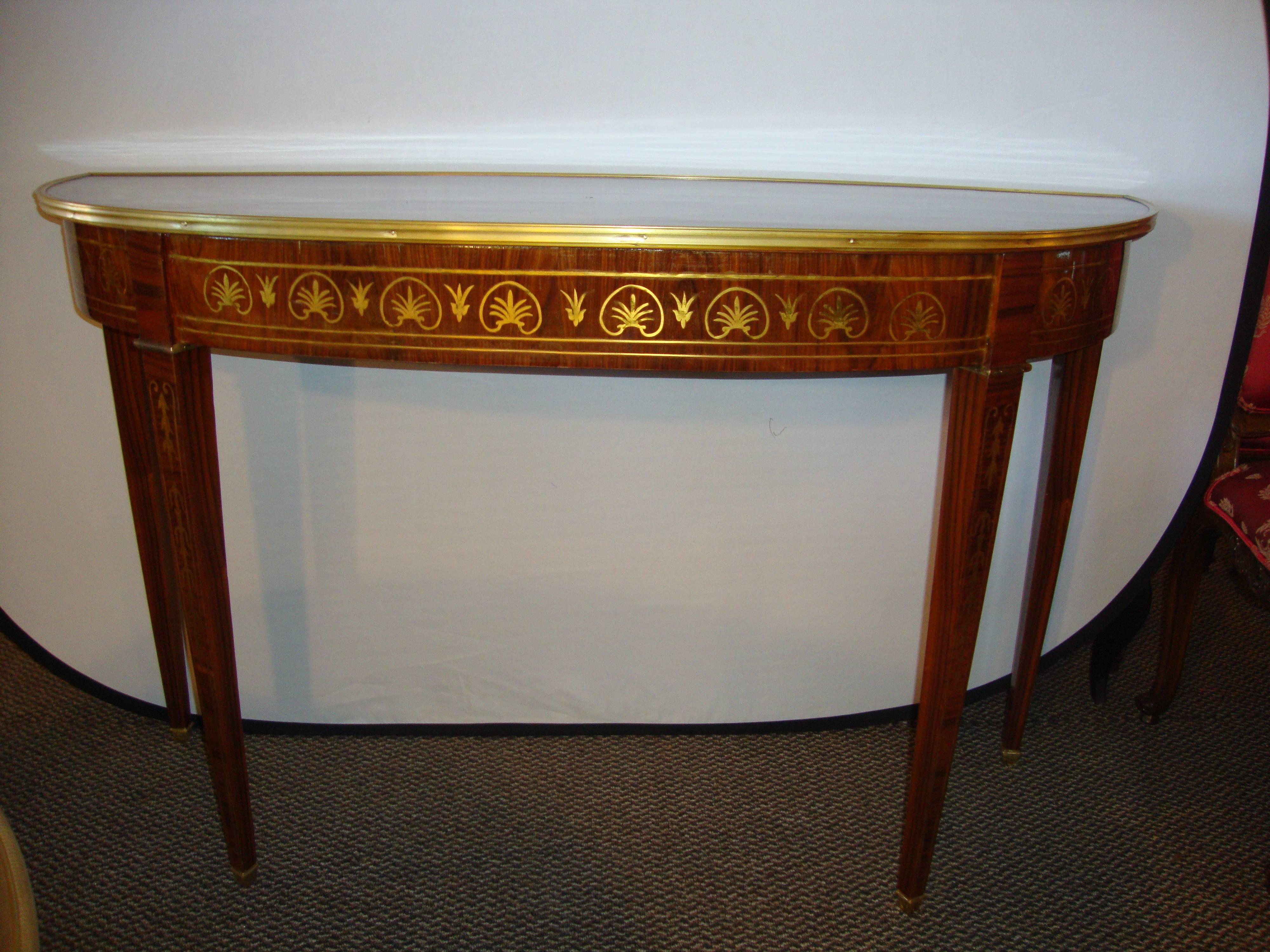 Finest Boulle inlaid demilune console. This recently polished, demilune console table with all-over boulle (brass) inlays. The tapering Louis XVI stylized legs with floral inlays supporting an apron of Fine brass inlays leading to a wonderful