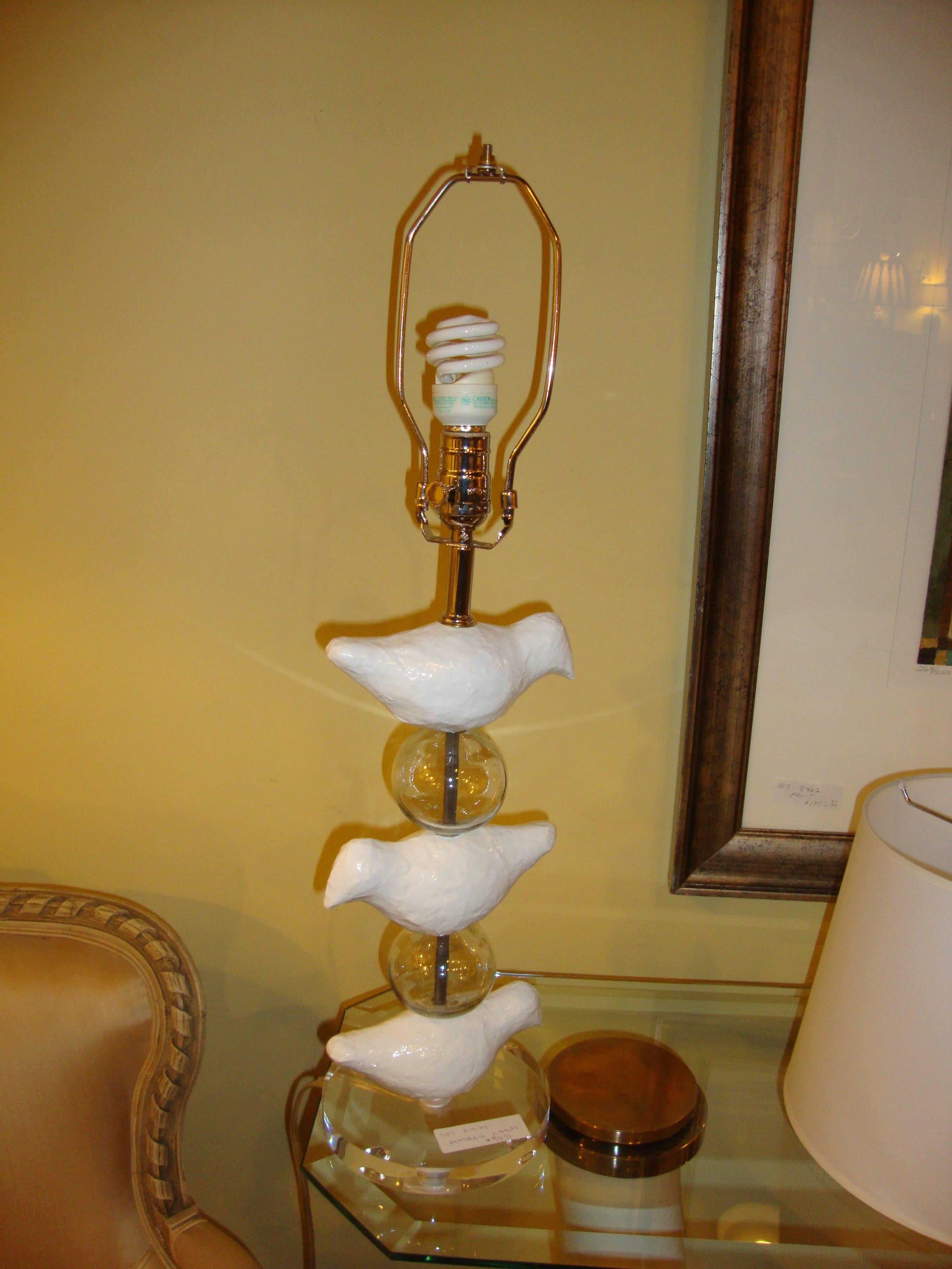 Pair of Lucite lamps depicting birds with bird finial. Each lamp having a centre stem supported by a Lucite base with three birds perched on circular balls.