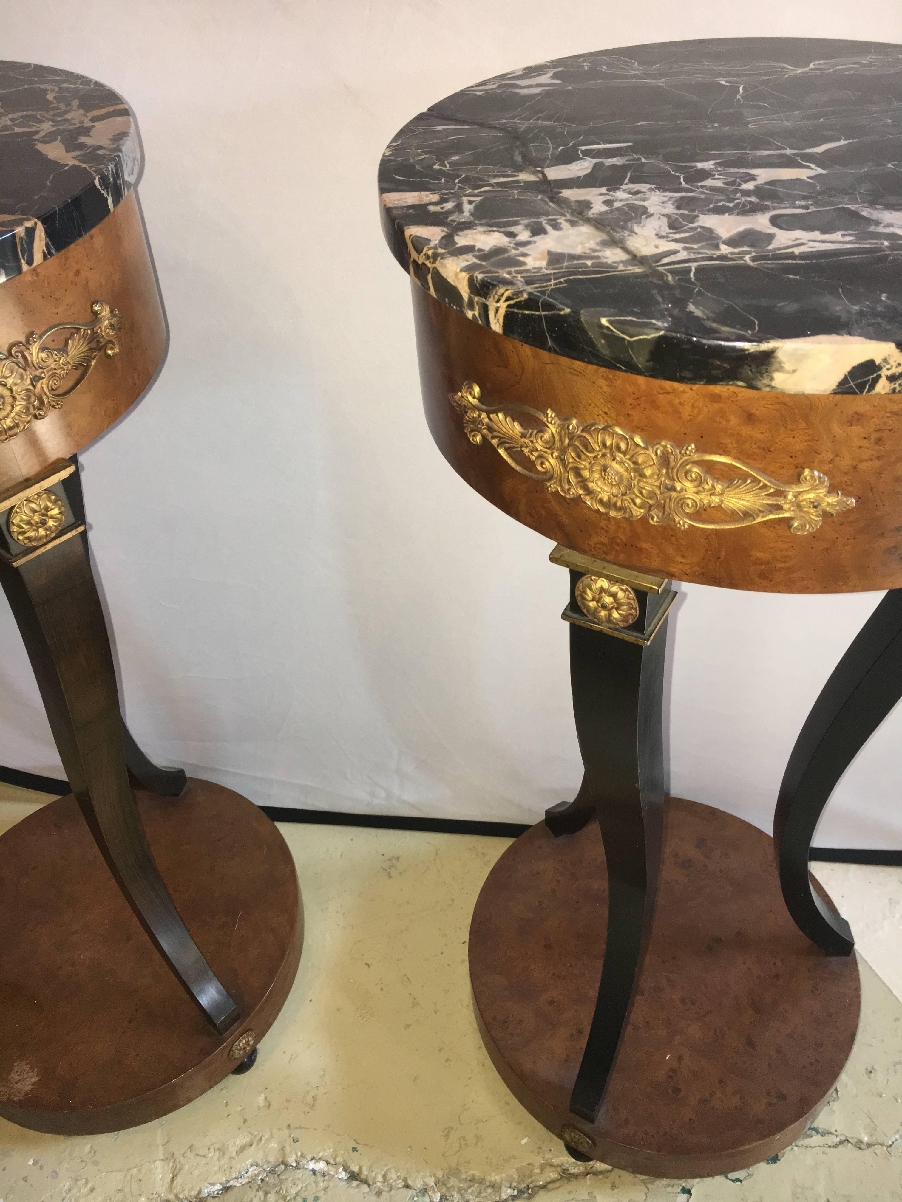 Pair of Empire style marble top pedestals. Each with bronze mounts. Ebony and burl wood decorated sitting on small ebony bun feet. Very decorative.