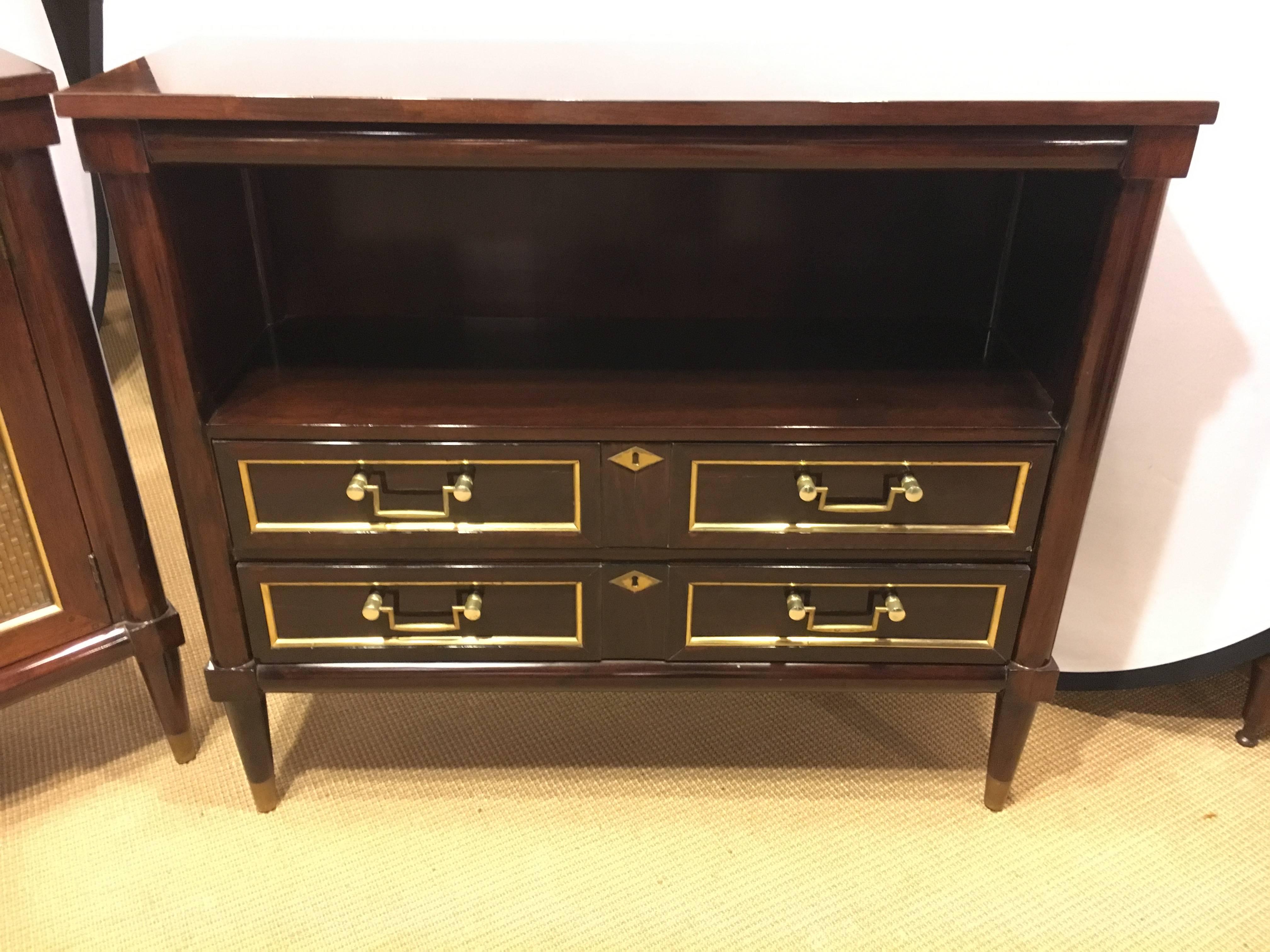 Bedside or end cabinet in the Jansen style. Simply the finest quality in this bronze framed mahogany cabinet or bedside stand. The case having an open bookcase over two custom crafted drawers. The front and sides having bronze framing mounts.