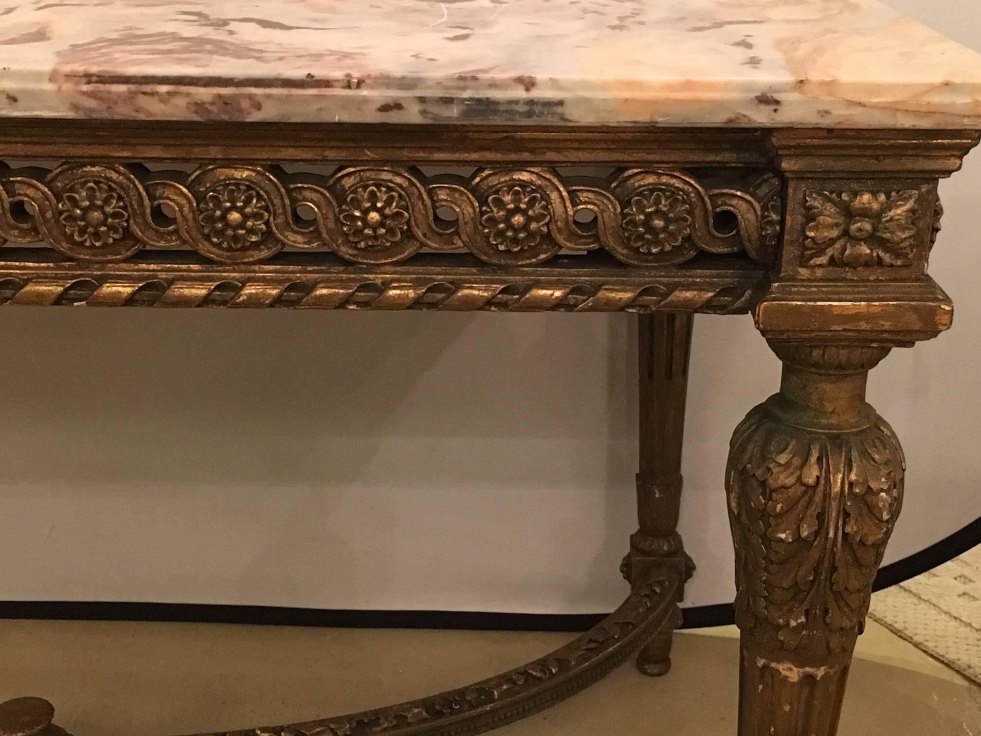 Stamped Jansen centre table having a gilt base and fine pink, grey and white veined marble-top. The top having been professionally repaired. The Louis XVI style centre table having been antique guided. The four corner legs supported by X form carved
