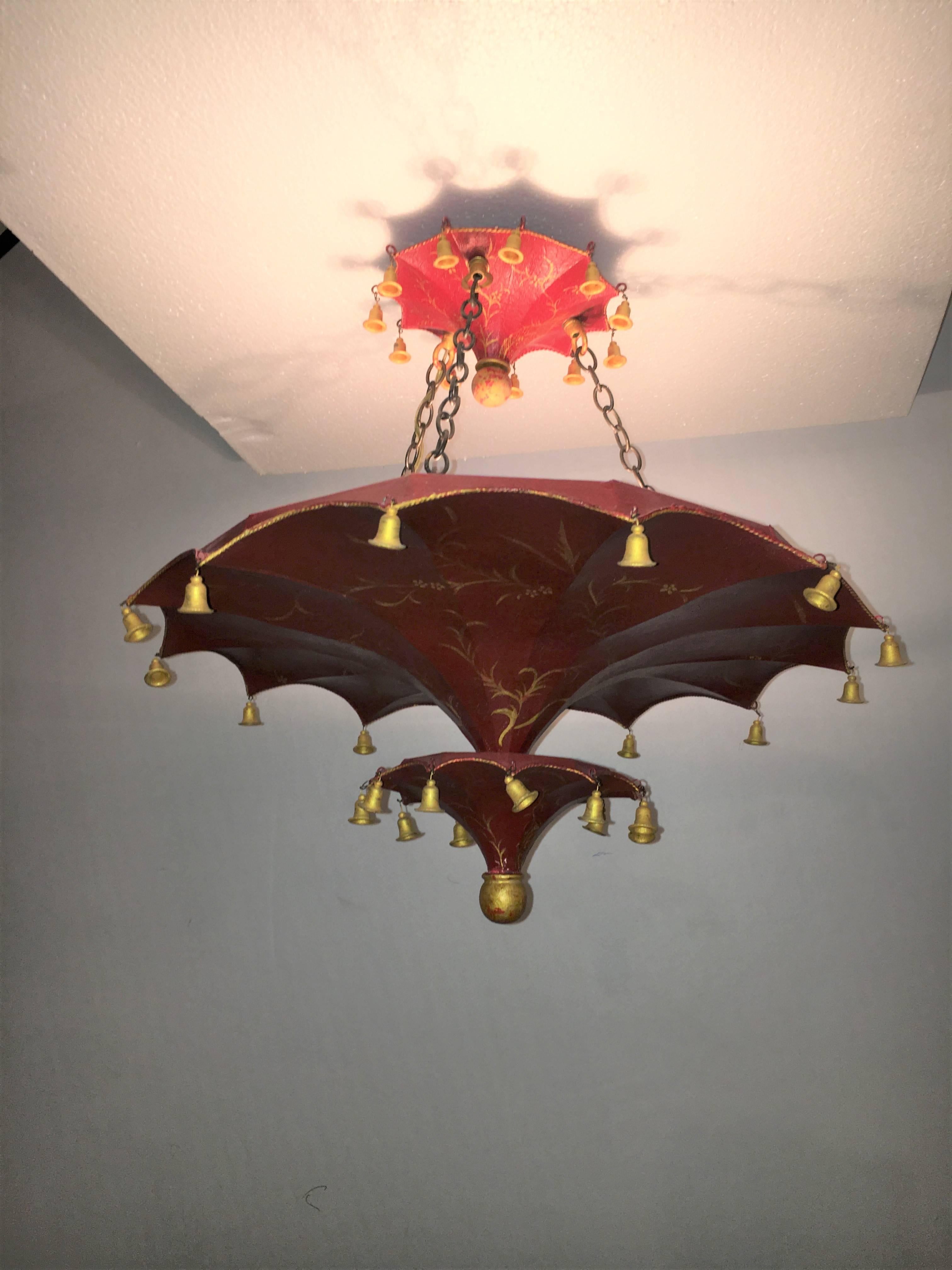 Wired with three interior lights this ceiling mount chandelier has a fire red finish and can either mount directly to the ceiling or hang on a chain. The upper
canopy and lower umbrella form decorated with flowing design. The gilt gold bells that