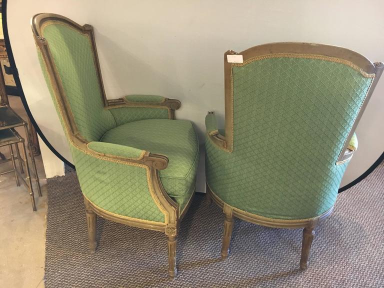 A pair of Maison Jansen stamped Louis XVI style armchairs with new green upholstery. Wonderfully distressed. This fine pair of light green paint decorated bergere chairs are in their original painted finish. Having squared backed and stuffed seats