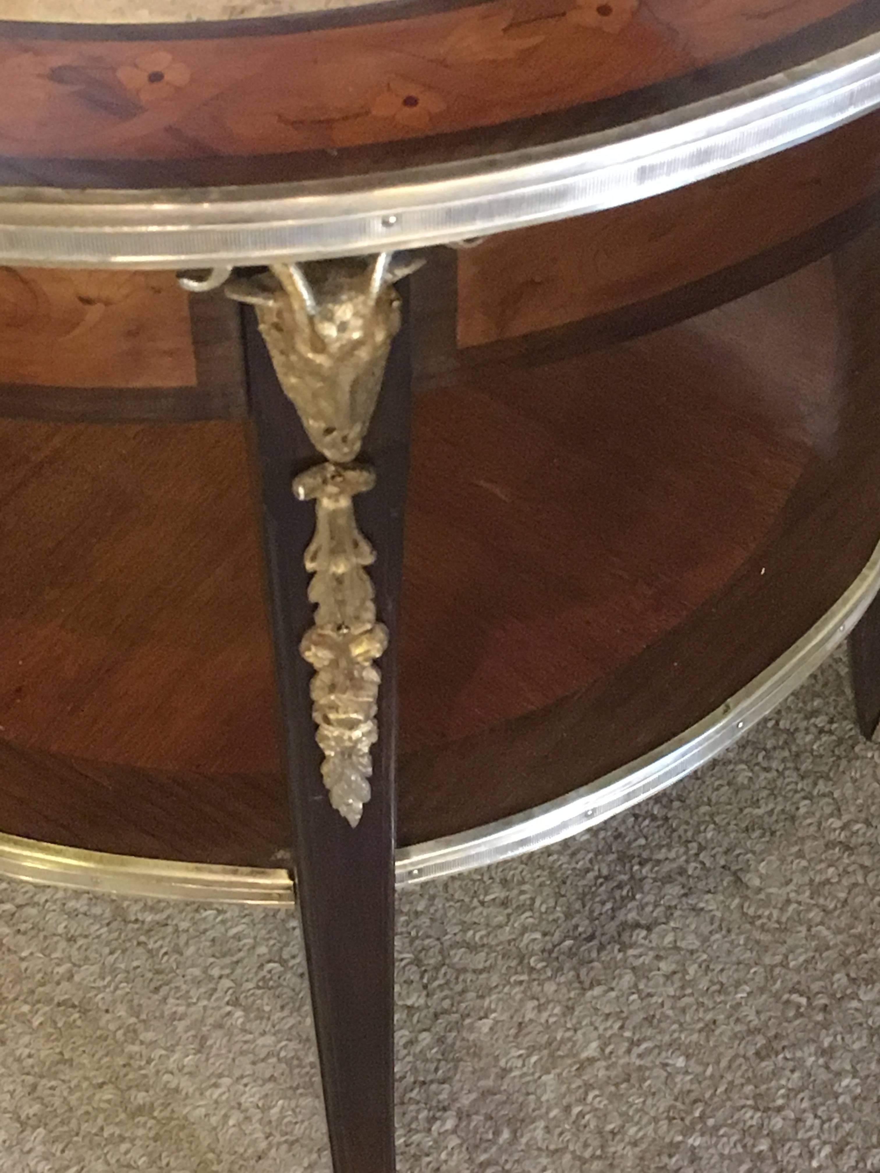 Pair of Large and Impressive Louis XV style marble-top tables or guerdons with rams heads. A spectacular pair of Louis XV style circular end tables. Each bronze claw foot leading to a curved group of legs supporting a bronze framed lower shelf and