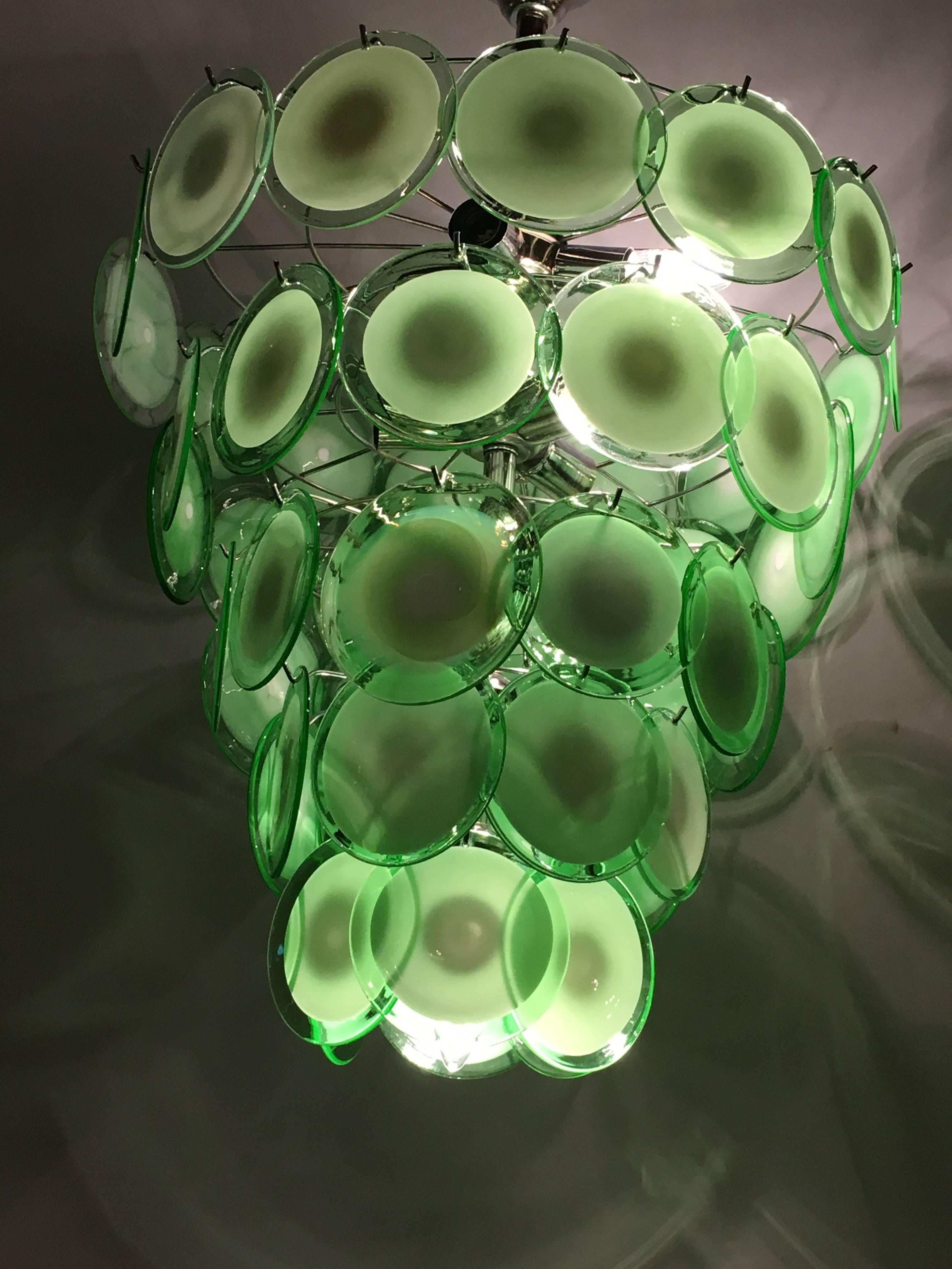 A pair of art deco style circular Murano glass sphere chandeliers. Each having fifty circular Murano glass spheres approximately six inches in diameter. This pair having mint green and white glass disks. We have recently acquired a warehouse which