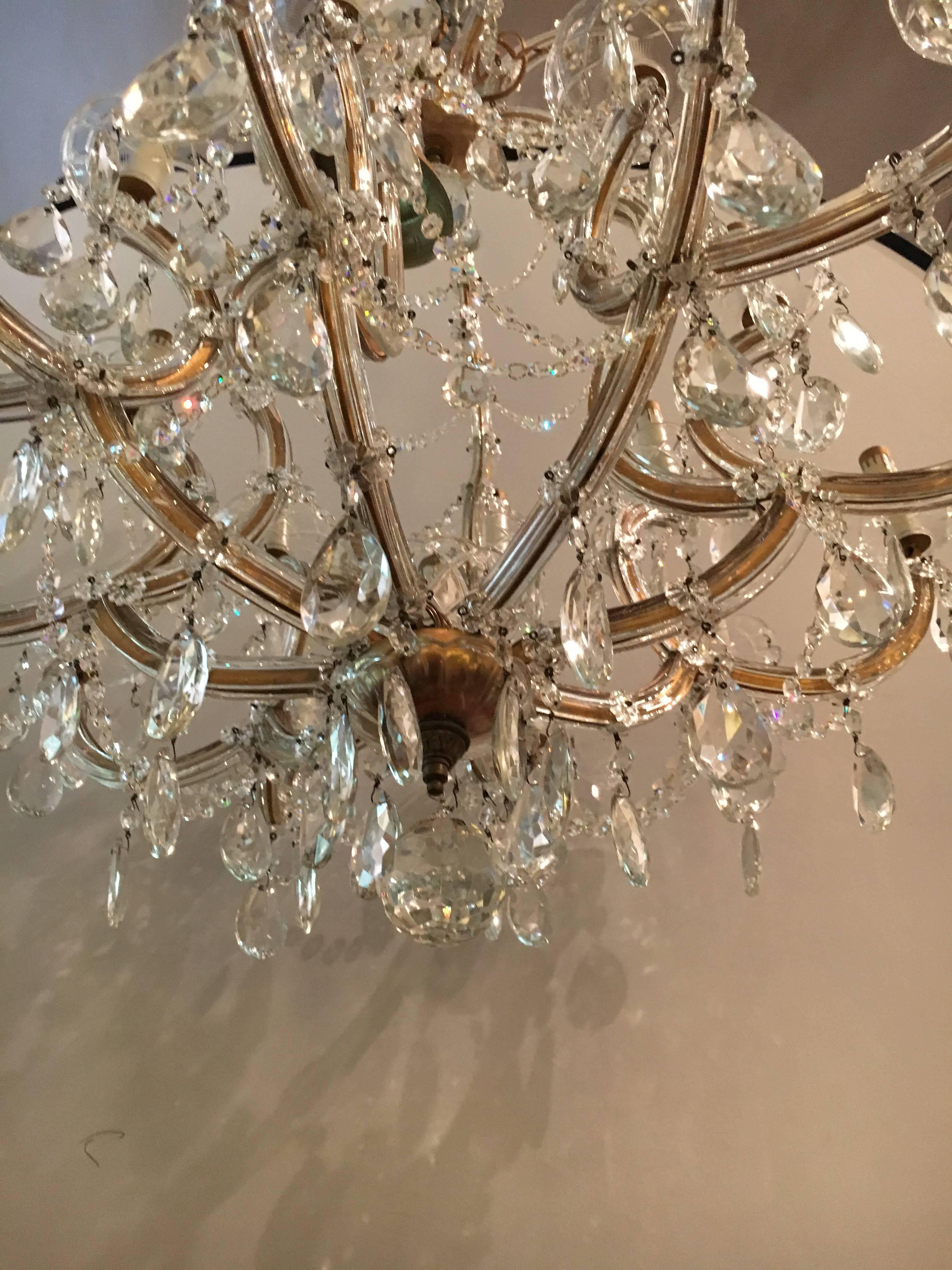 A Pair of Antique Venetian Twenty-one Light Chandeliers. A pair of newly wired circa 1920s Venetian Chandeliers. Each having a long chain and canopy. Both with an enormous amount of finely cut crystals. SXAX