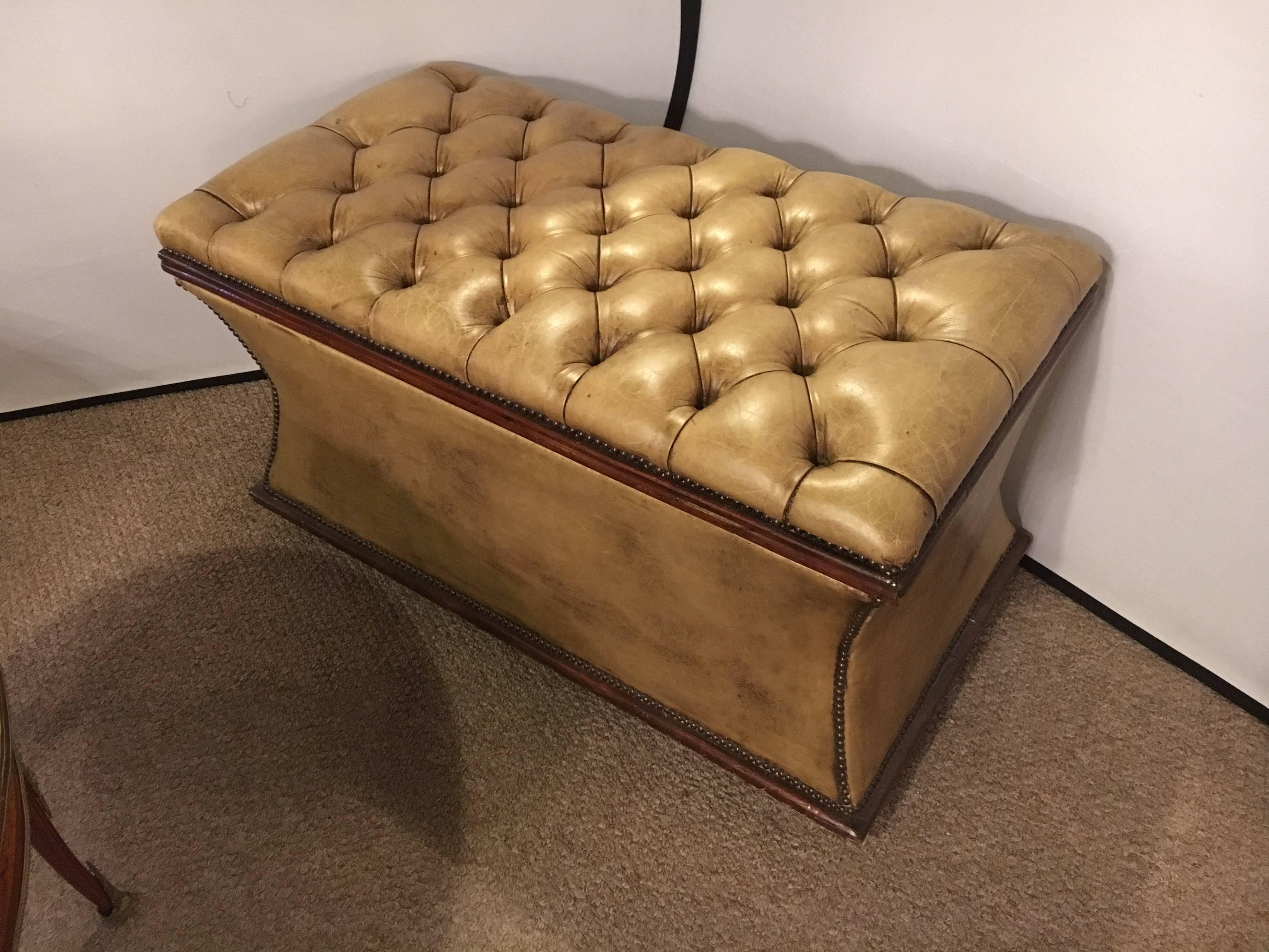 Antique English tufted leather storage chest or dowry. Supported by bun feet on a mahogany apron is this fine leather chest or bench. The inverted sides and front make this stylishly fashioned chest a must have at the foot of your bed or as a foot