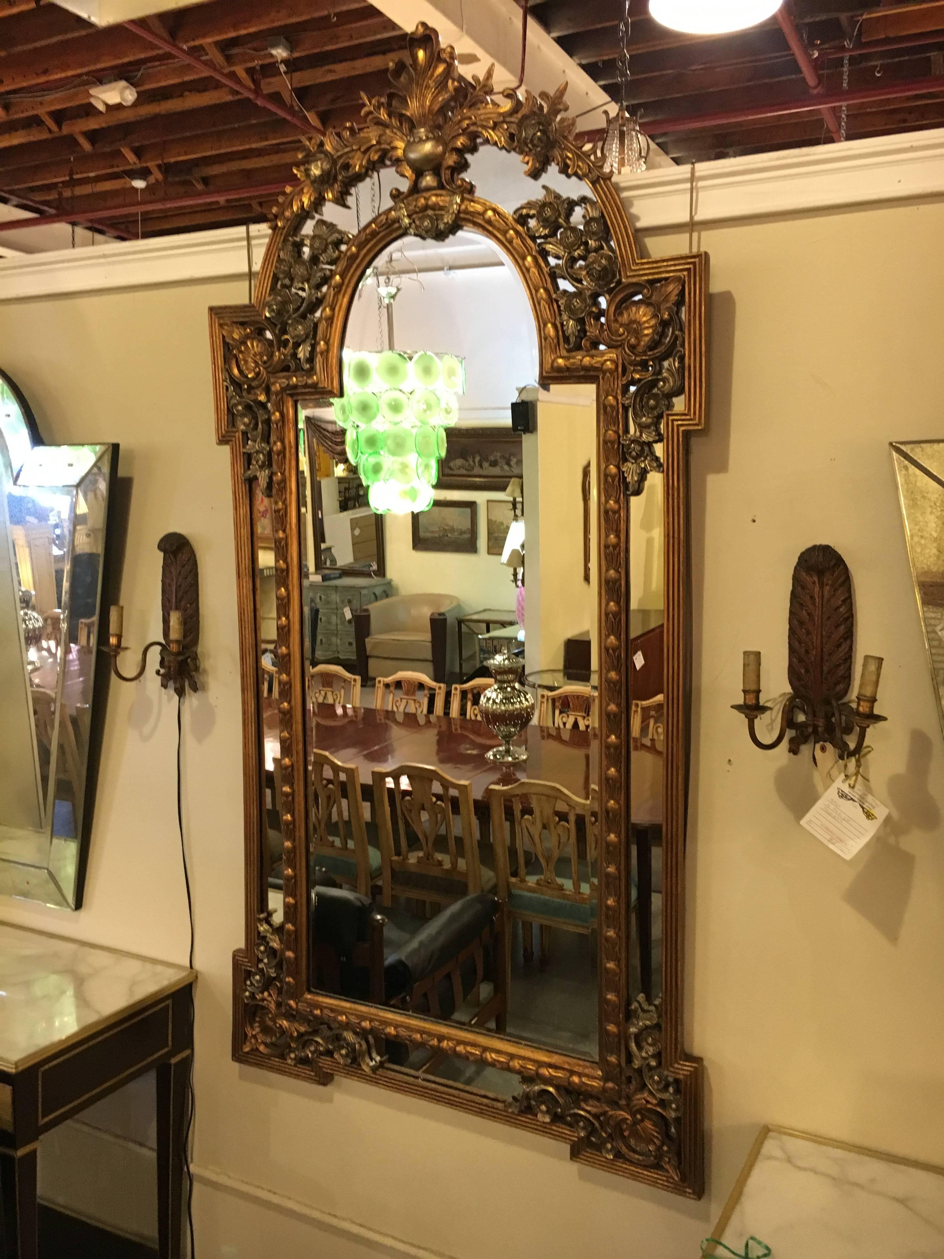 Monumental French carved floor or console or pier mirror. The centre clear and clean mirror having a frame of scroll and floral with shell carvings.