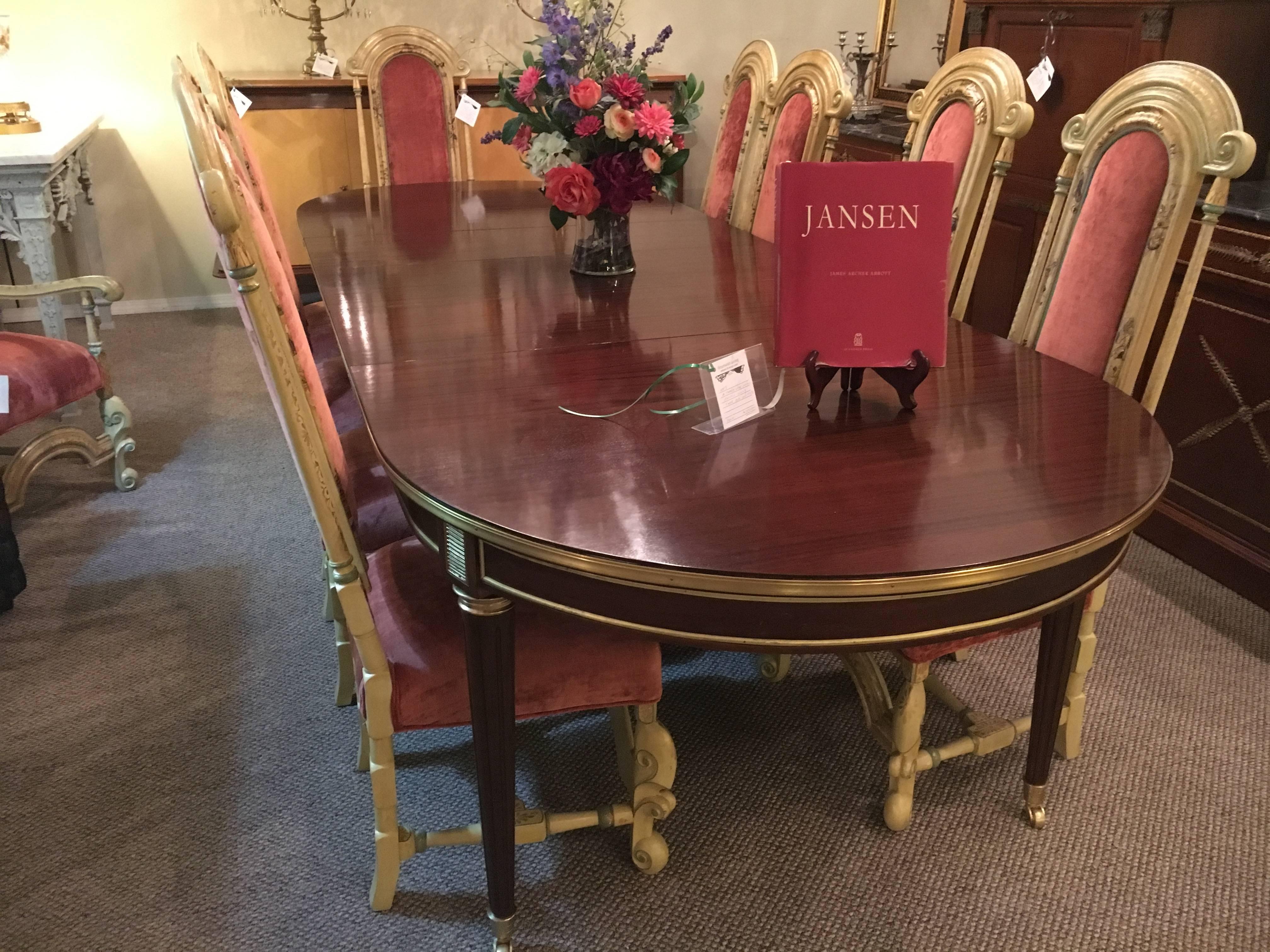 A two-leaf Maison Jansen style Rosewood Dining Table bronze-mounted. A fine Maison Jansen style dining table in the Louis XVI style. The tapering bronze-mounted legs with fluted design having bronze casters on sabots. The rosewood apron with