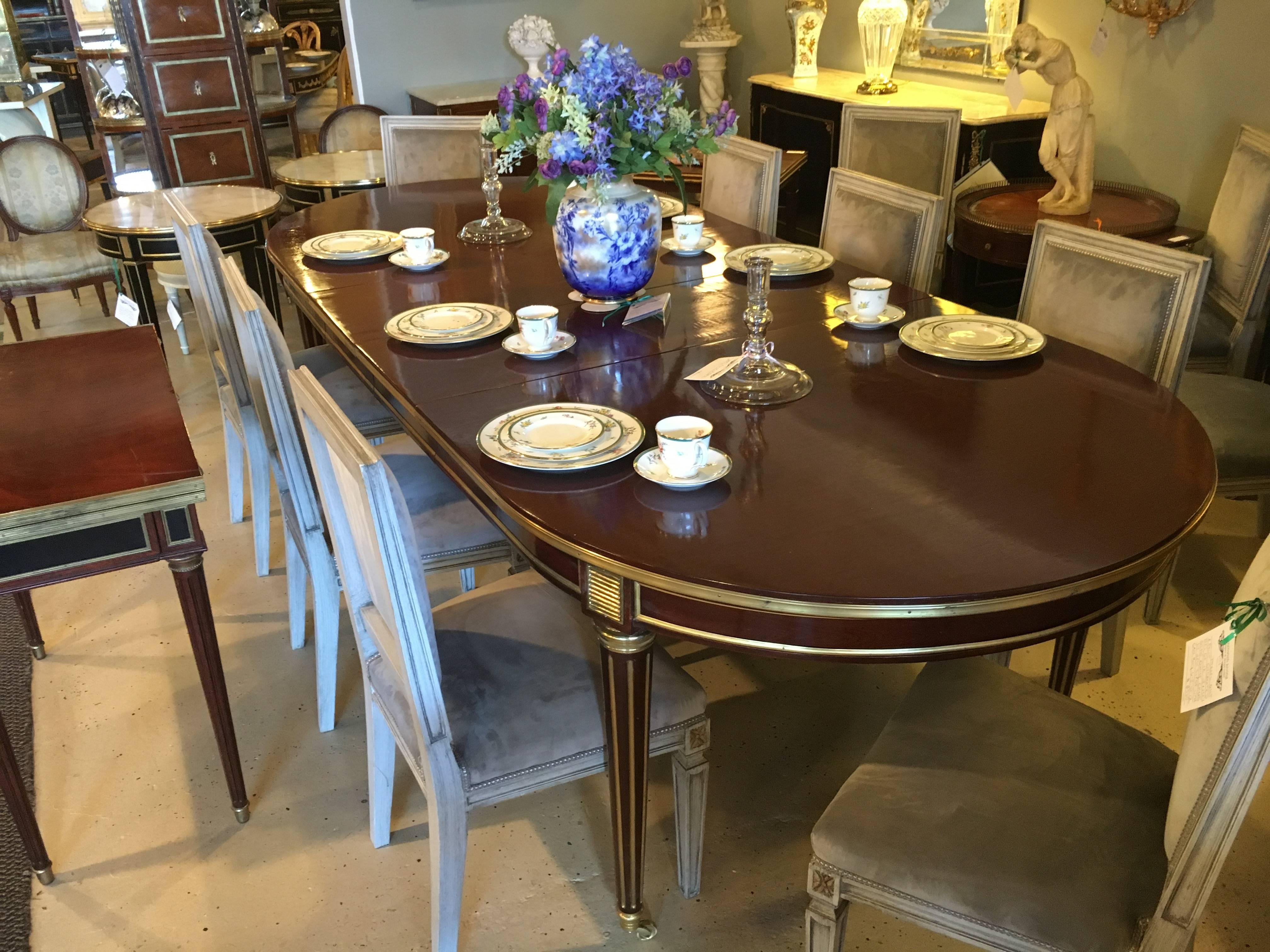 Louis XVI style mahogany dining table manner of Maison Jansen. A spectacular Louis XVI style dining table possibly by Maison Jansen having three 15.75 inch expandable leaves. Wonderfully done in a hand rubbed French polish finish. The solid bronze
