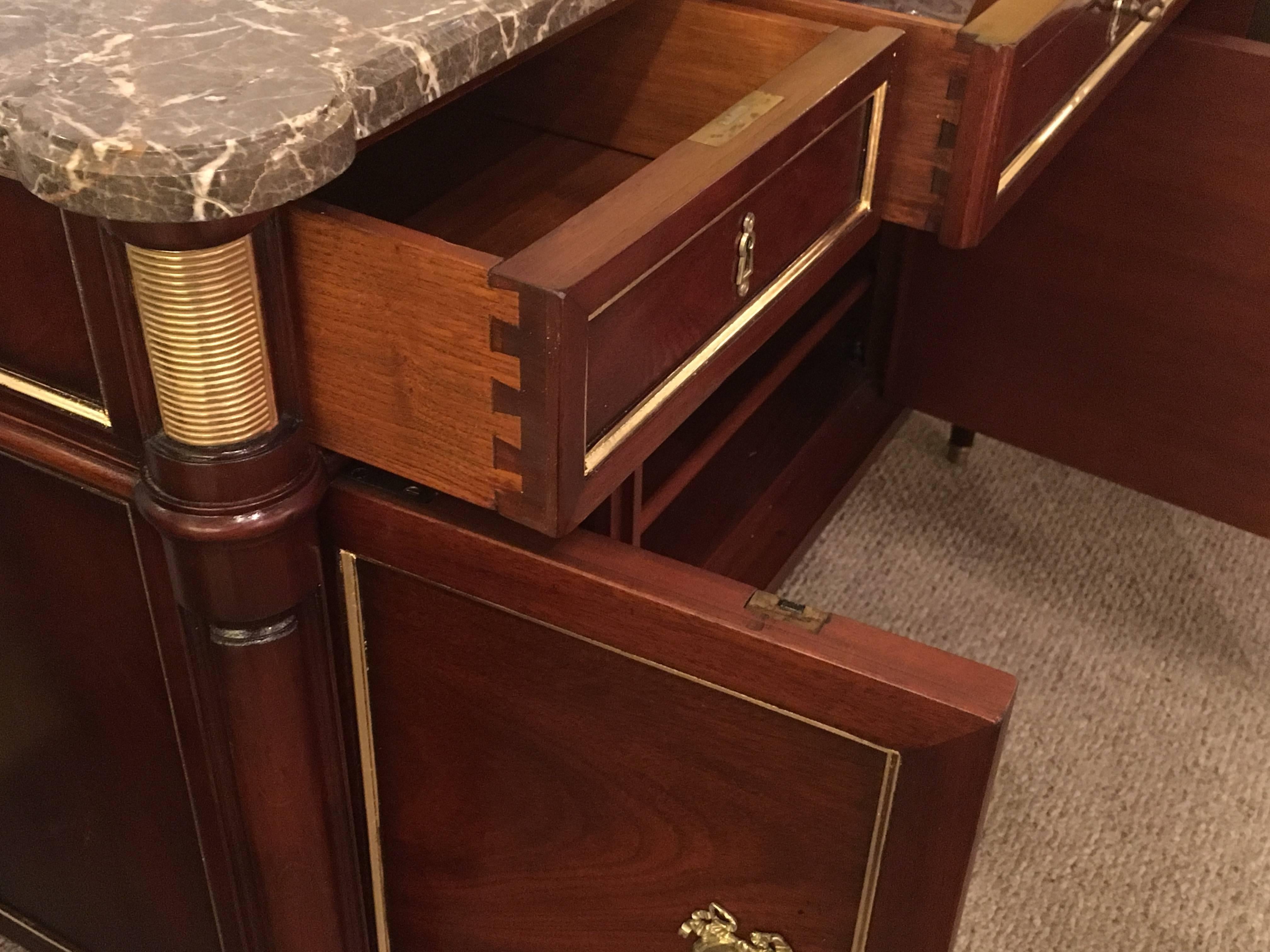 Pair of French bronze-mounted Maison Jansen Louis XVI style commodes, circa 1940s. This outstanding pair of commodes or bedside cabinets each have bronze-mounted tapering legs supporting a case of three drawers over three doors all having bronze