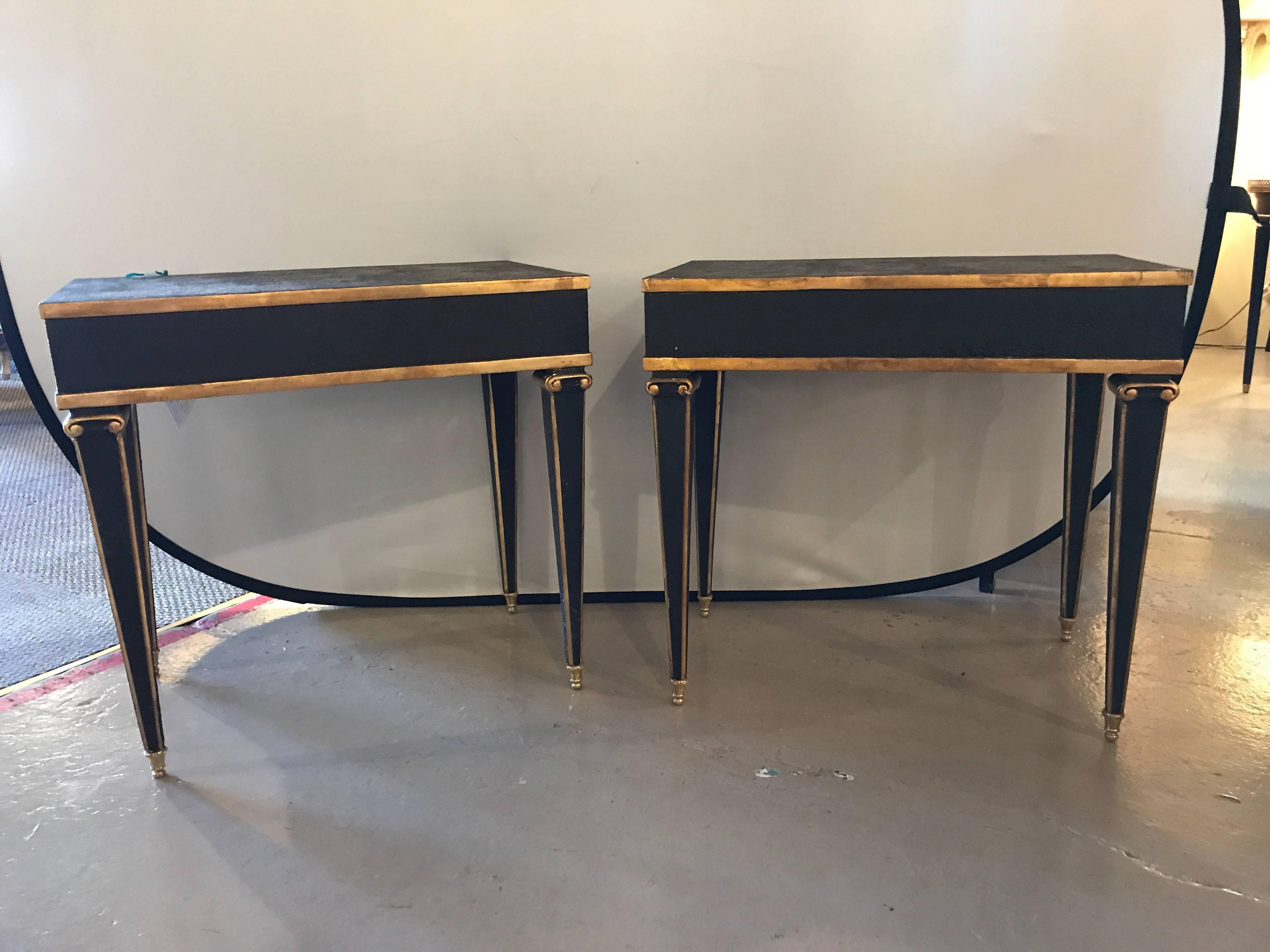 Fine Hollywood Regency style pair of Maison Jansen fashioned end tables with leather top and bronze-mounted legs each distressed in an ebony finish with gilt hi lights with carved tapering legs. This pair modeled after a very popular design by this