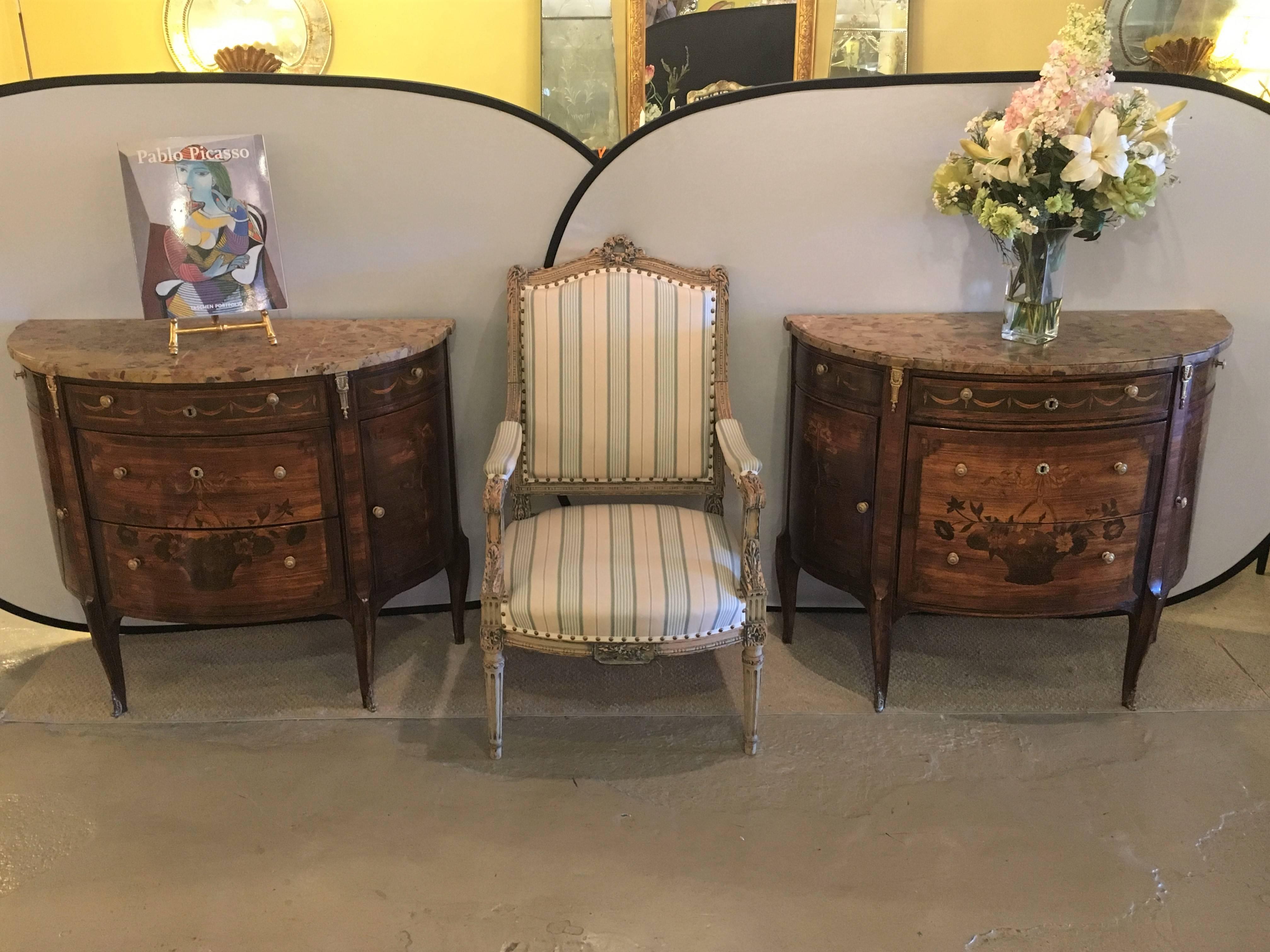 A pair of 19th century French Louis XV Style demilune commode / bedside stands. A fine pair of custom quality Louis XV style commodes. The deep demilune form having three drawers in the centre with a large basket of inlaid flowers on the larger two