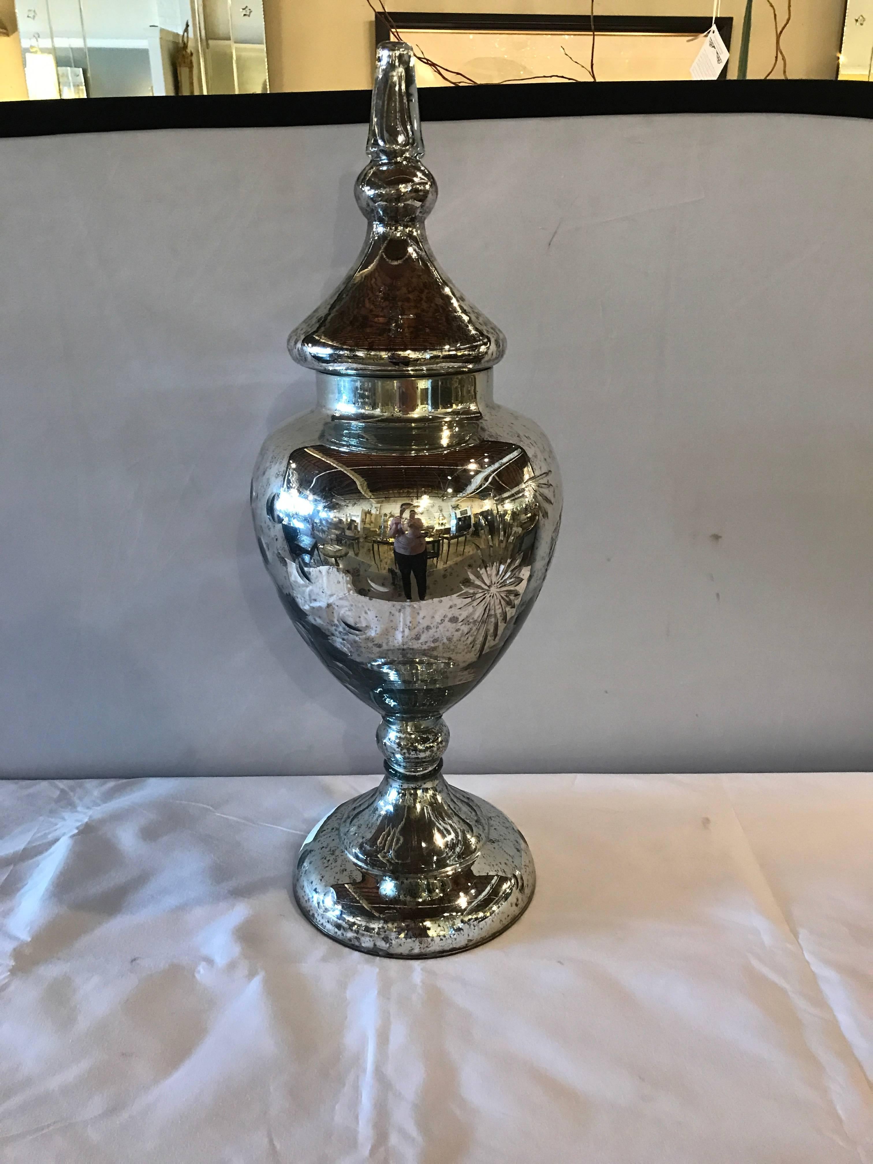 A pair of decorative mercury glass silver etched lidded urns. Several pair available. The price quoted if for one pair only.