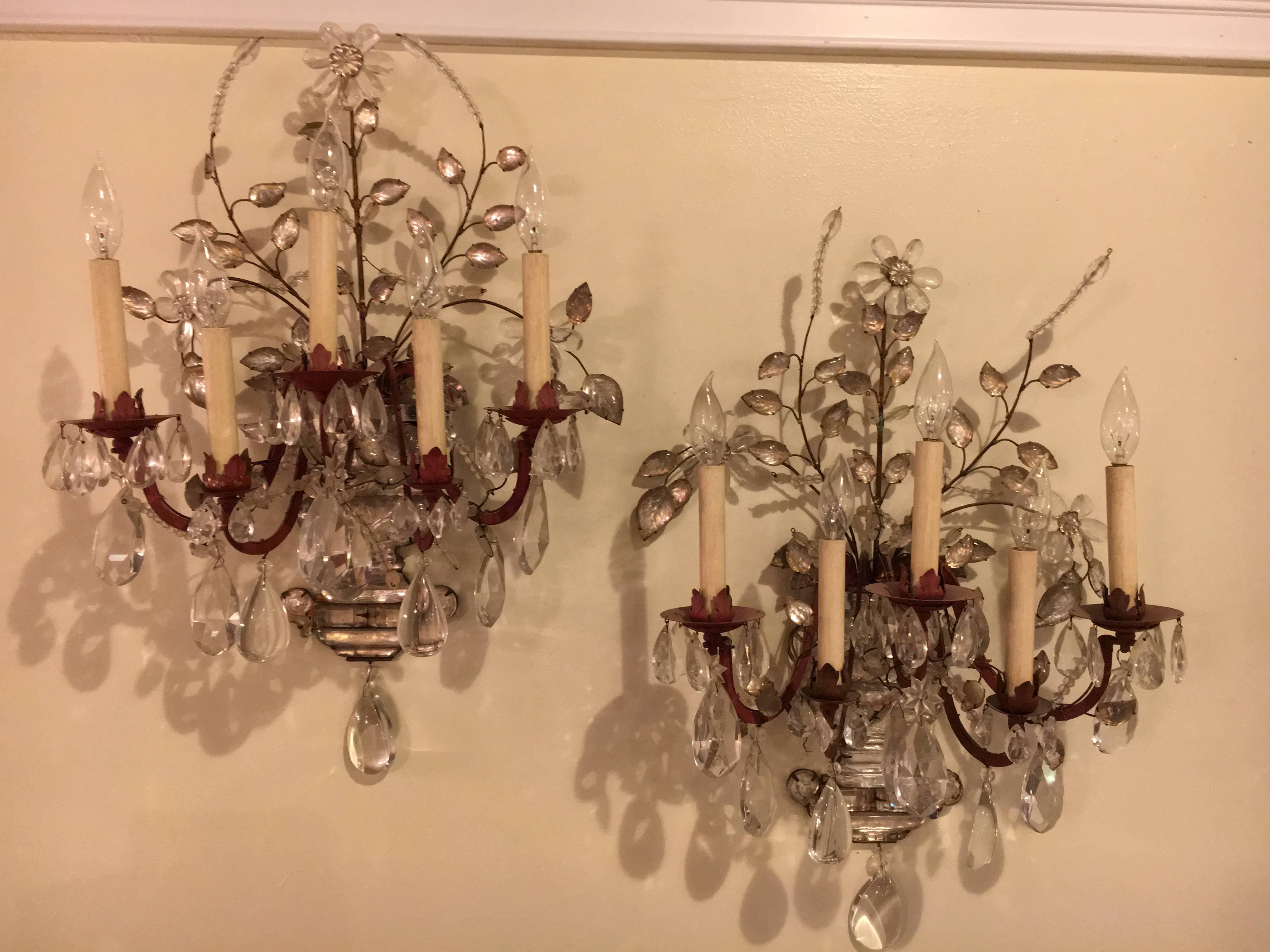 Set of four crystal and bronze five light wall sconces in the manner of Maison Bagues. A fine set of four wall sconces each having five lights. The back plate of crystal basket form having a flowing group of vines with leafs and rosettes of fine