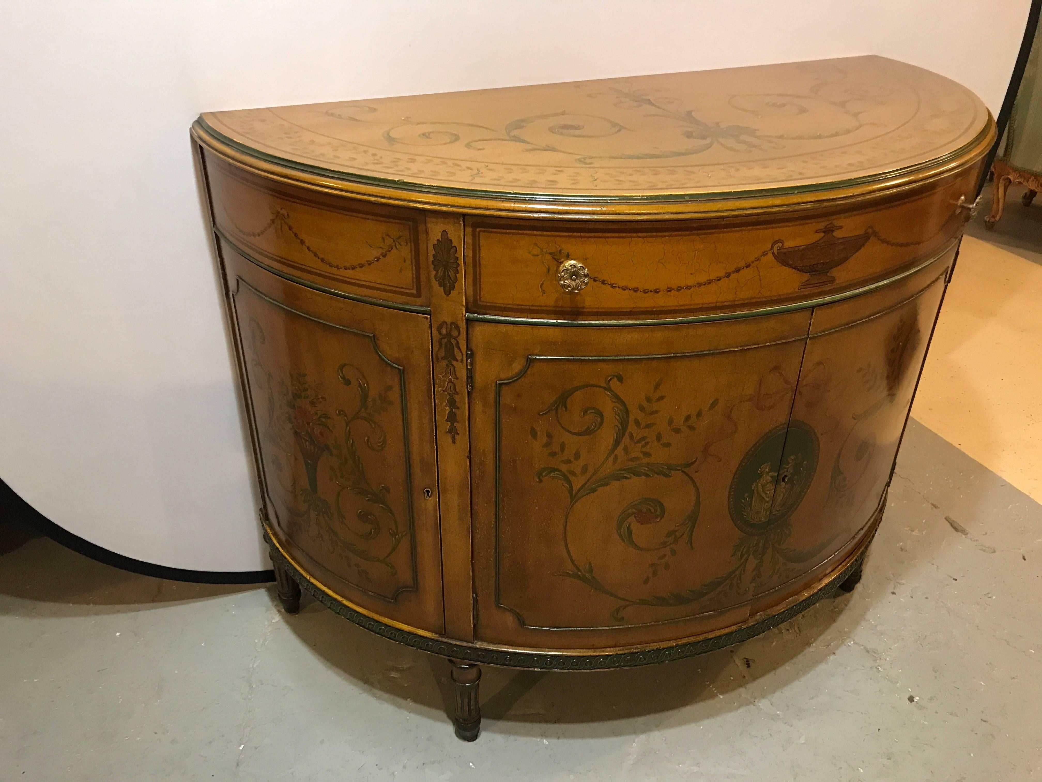 An Adams style paint decorated demilune commode or chest with interior drawers. This deep highly decorated demilune commode of Adams style has fine paint decorated features. The case itself having been French hand rubbed polished. The rare chest has