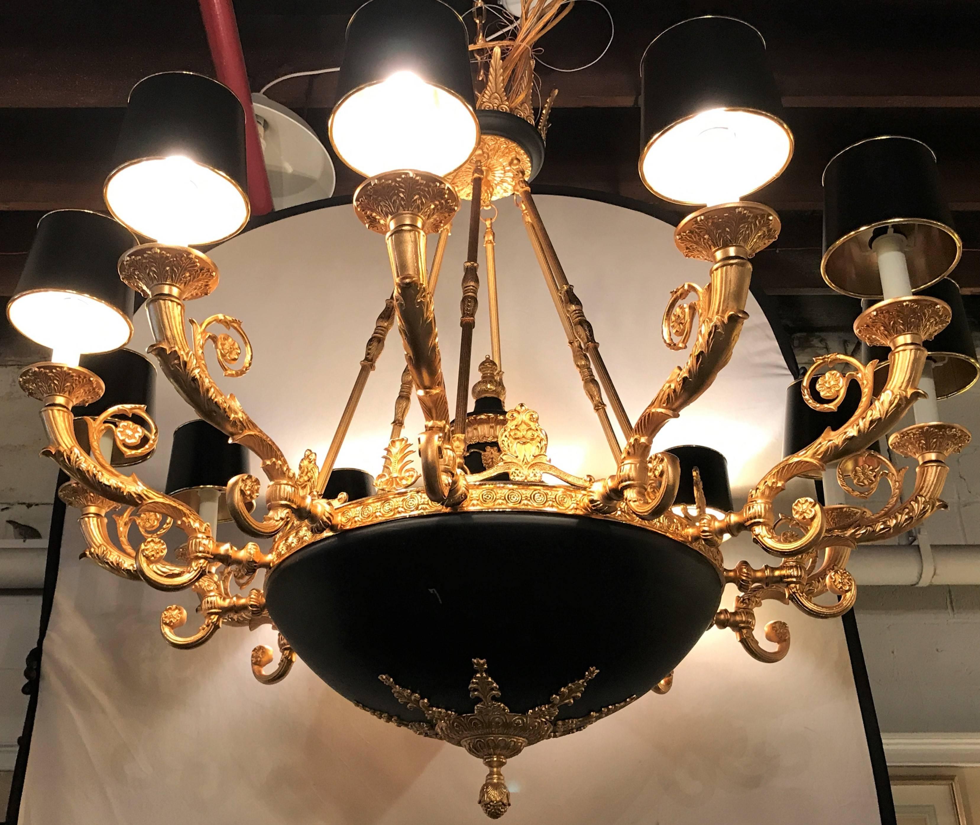 An Empire style twelve-arm chandelier with bronze and ebony high lights. Having a 76 inch chain and matching canopy, this palatial chandelier is certain to light up any foyer or living room with not only its twelve lighted arms but with the grace